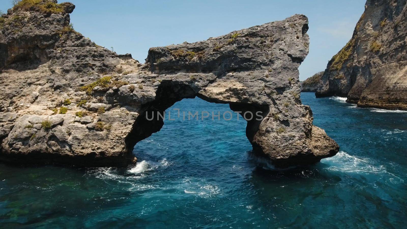 Rock in the ocean at Atuh beach on Nusa Penida island, Indonesia. Aerial view of Rocks in a blue sea lagoon with breaking waves. Travel concept.