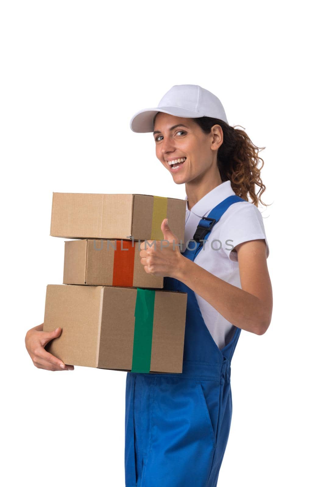 Portrait of happy smiling delivery woman with stack of boxes showing thumb up isolated on white background