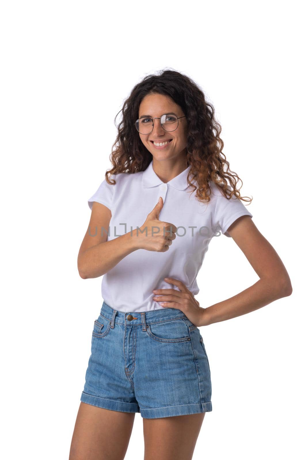 Portrait of young woman in glasses with curly hair showing thumb up isolated on white background