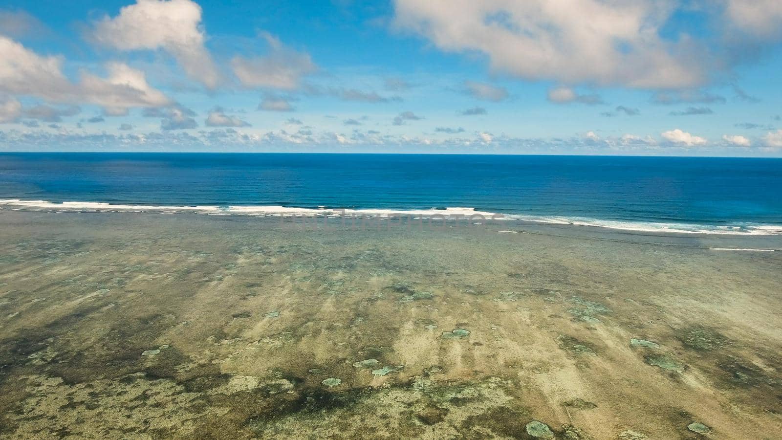 Flying over the blue sea in the azure lagoon. Aerial view: water surface. Tropical sea. Philippines. Flying over the azure surface of the ocean.
