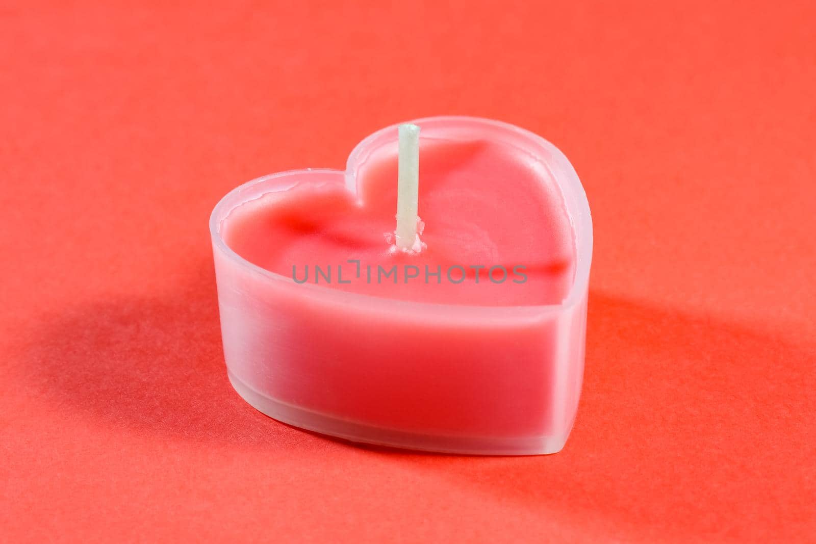 pink candles in the form of a heart on a red background for Valentine's day . High quality photo