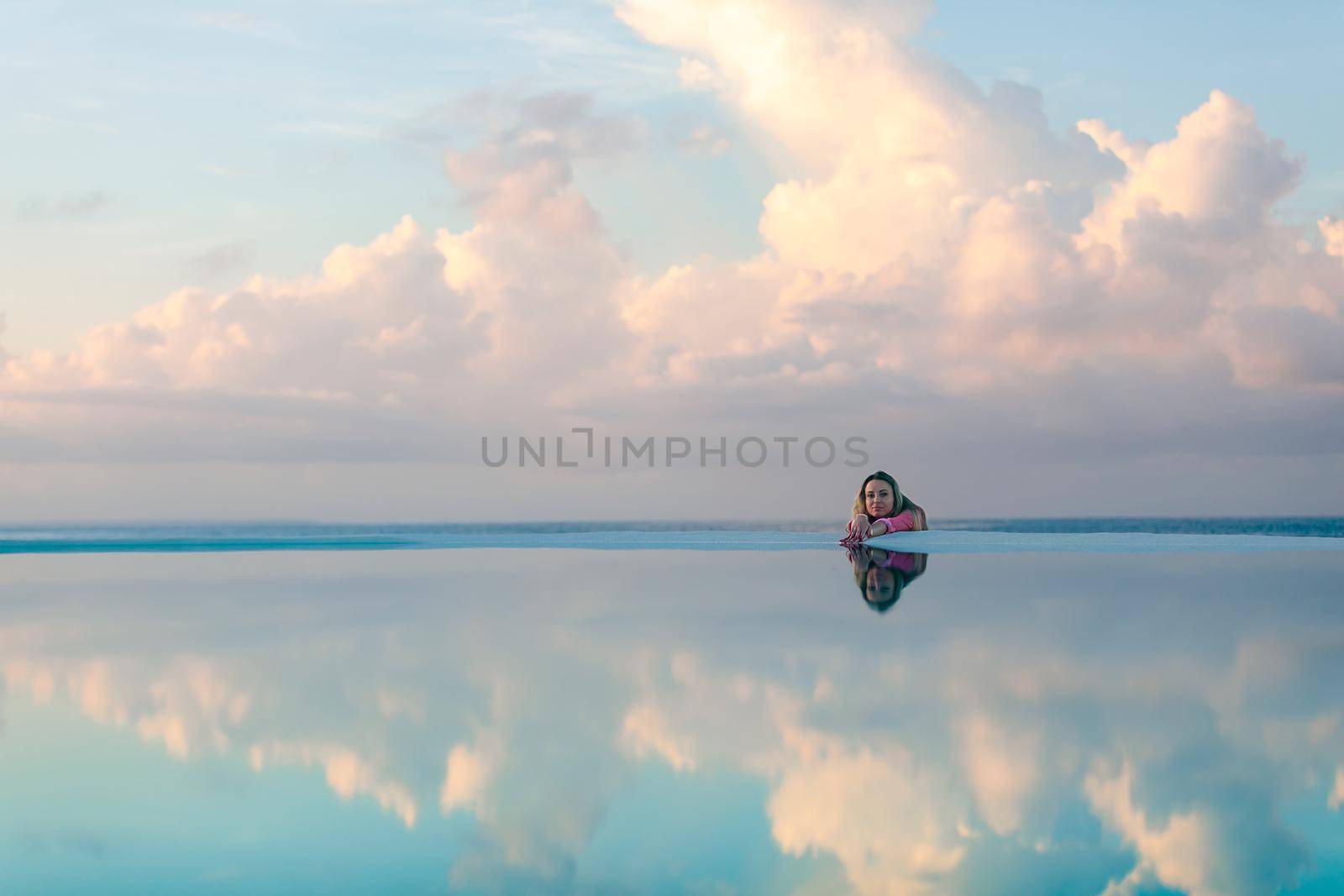 Young girl at dawn by the sea pool, calm and relaxed by Yurich32