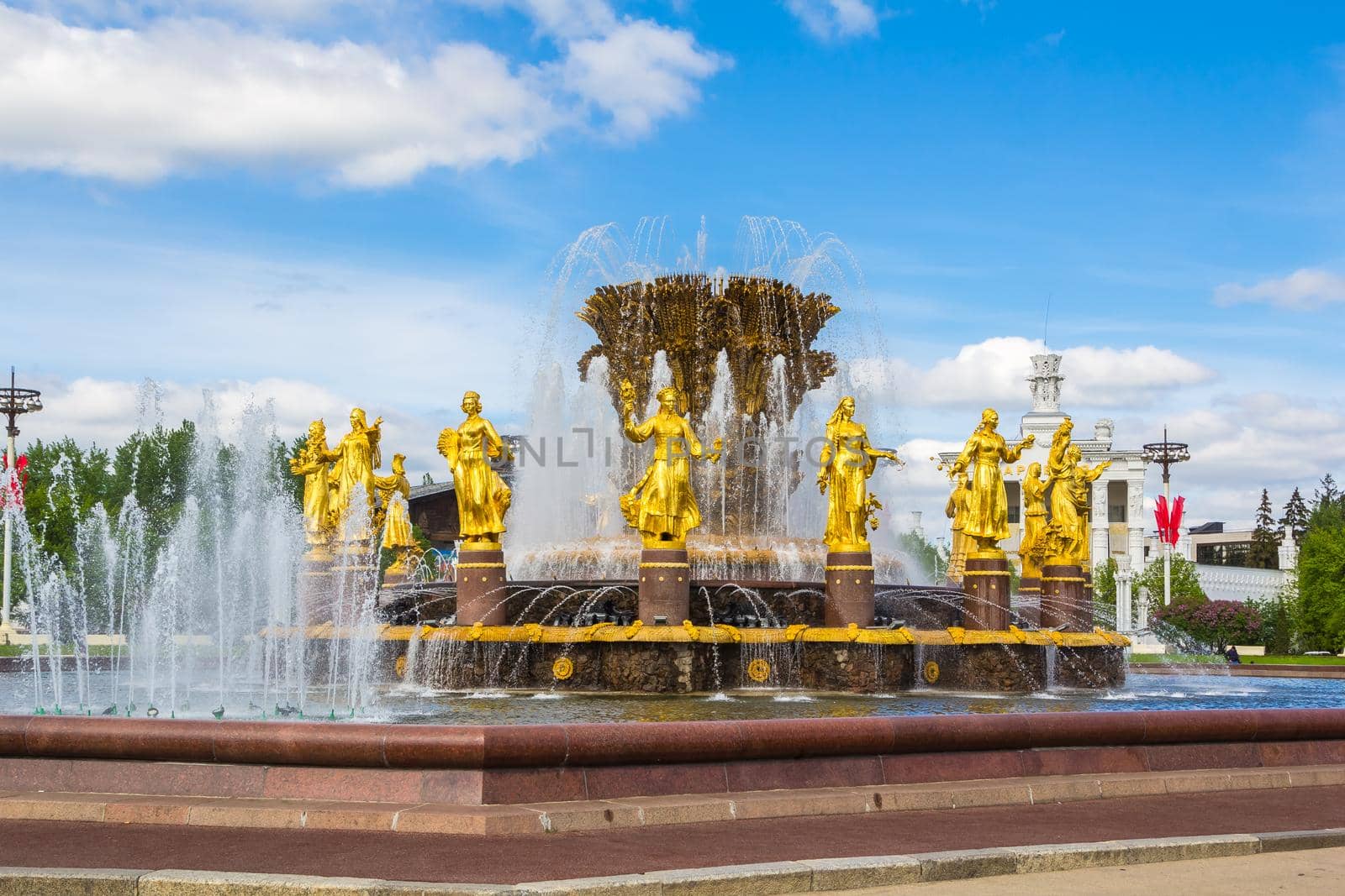 MOSCOW, RUSSIA-MAY 12, 2016: Peoples ' Friendship Fountain in VDNH Park in Moscow. Gorgeous view of the gilded fountain on the background of a tall building.