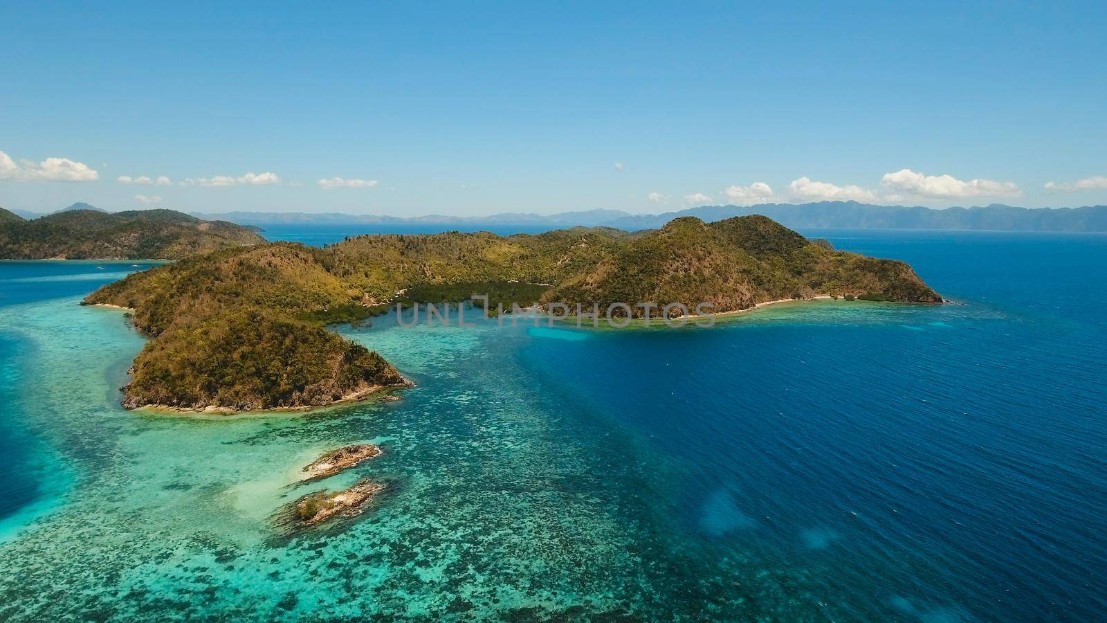 Aerial view: Lagoon with blue, azure water in the middle of small islands and rocks, Palawan. Beach, tropical island, sea bay and lagoon, mountains with forest, Coron. Busuanga. Seascape, tropical landscape. Philippines. Travel concept