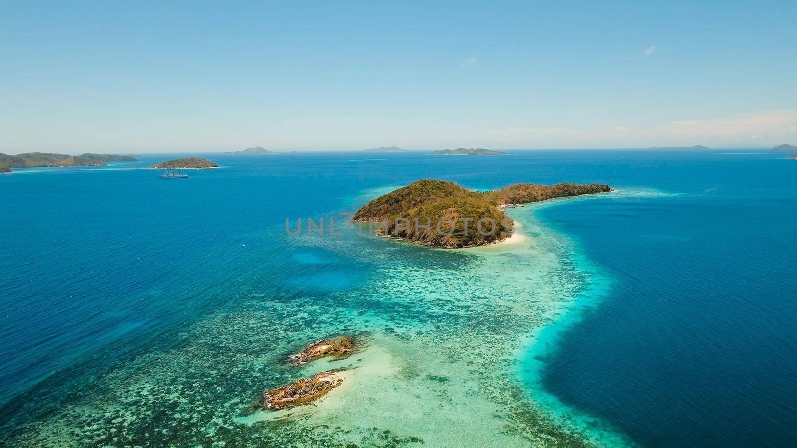 Aerial view: Lagoon with blue, azure water in the middle of small islands and rocks, Palawan. Beach, tropical island, sea bay and lagoon, mountains with forest, Coron. Busuanga. Seascape, tropical landscape. Philippines. Travel concept