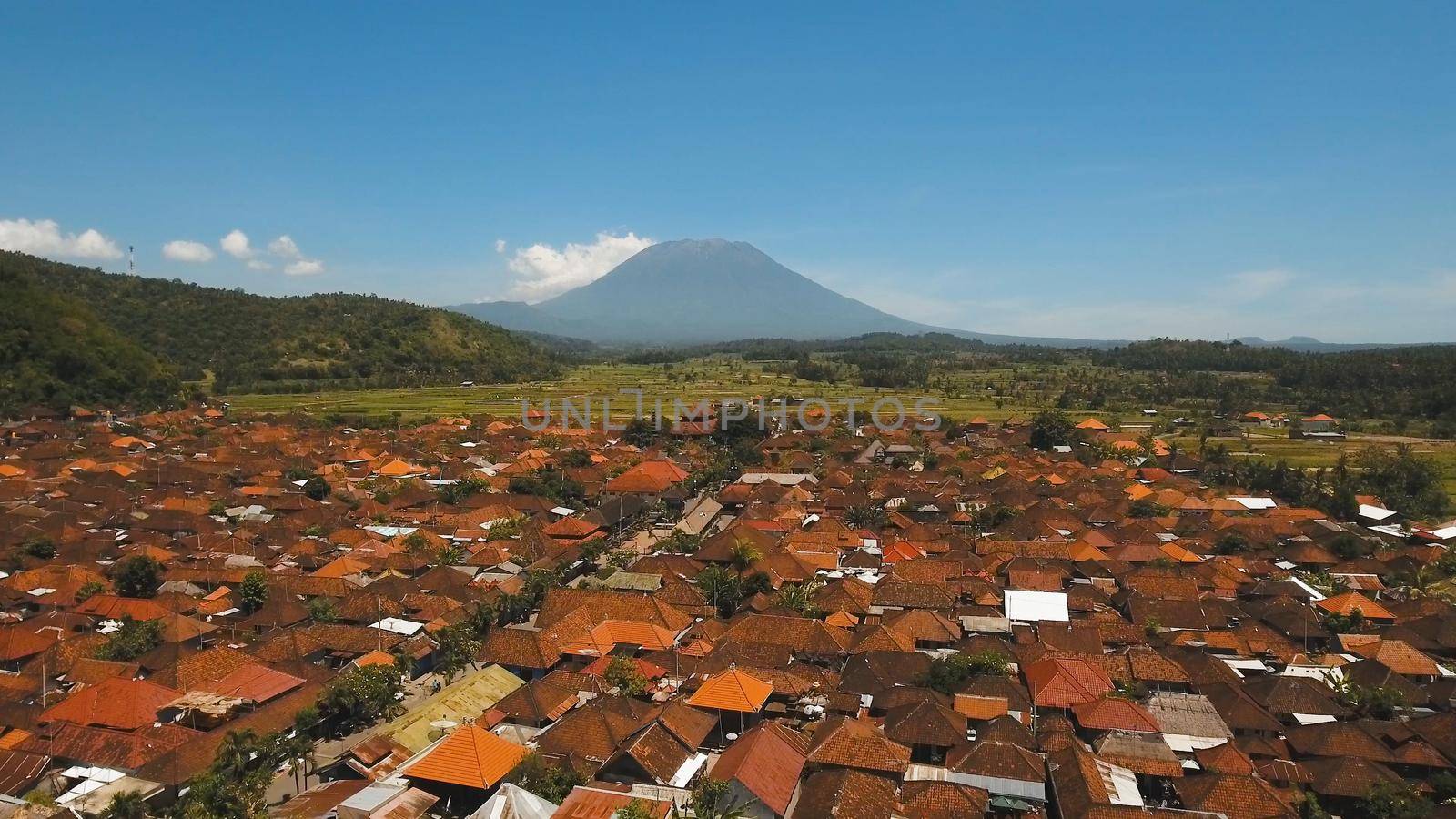 Aerial view Town near volcano Agung, rice terrace, farmlands, village, fields with crops, agricultural land of farmers. Bali, Indonesia