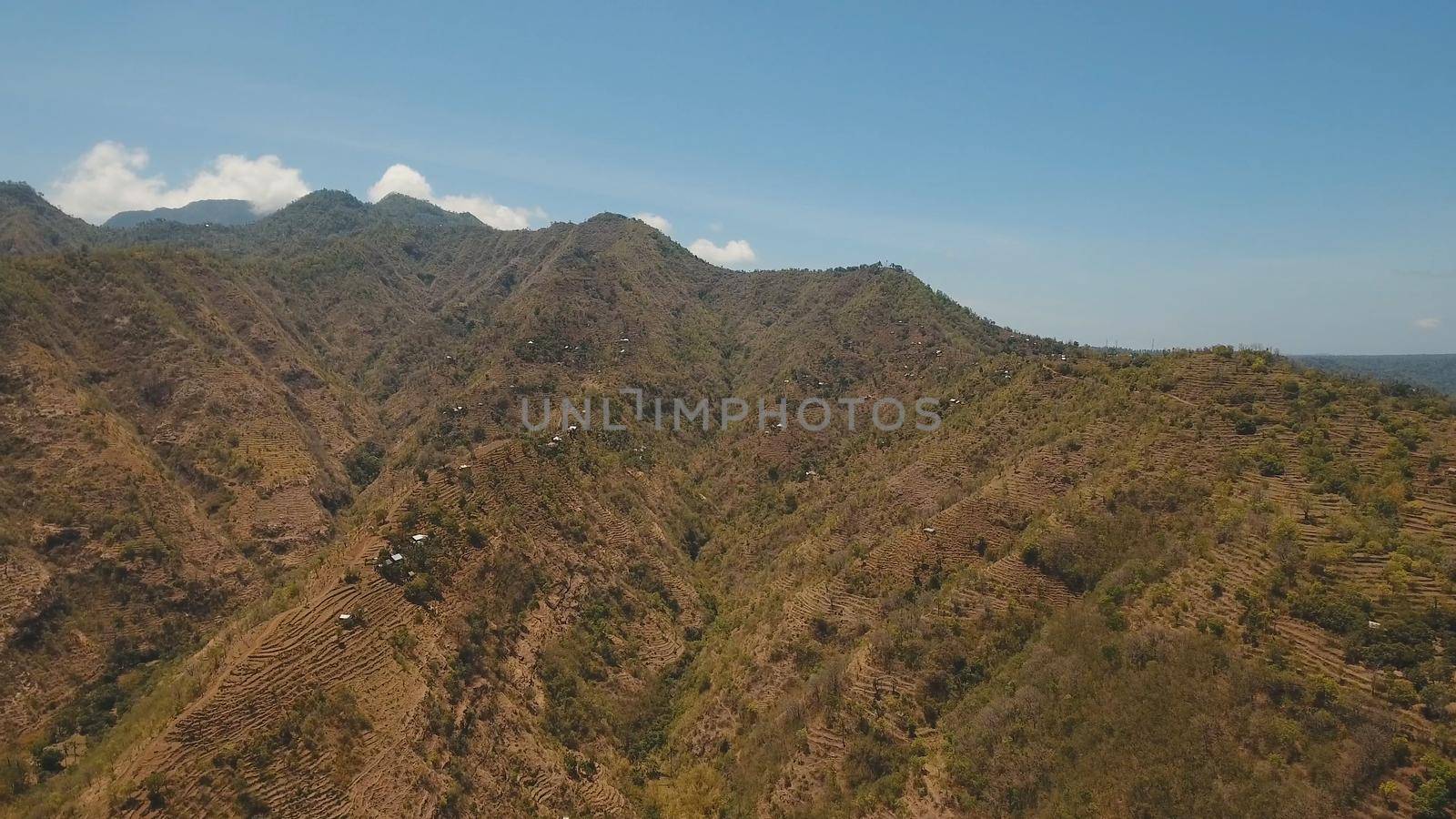 Aerial view of landscape, mountains covered with green forest, trees with sky and clouds, Bali,Indonesia. Slopes of the mountains are covered with forest in Asia. Travel concept.