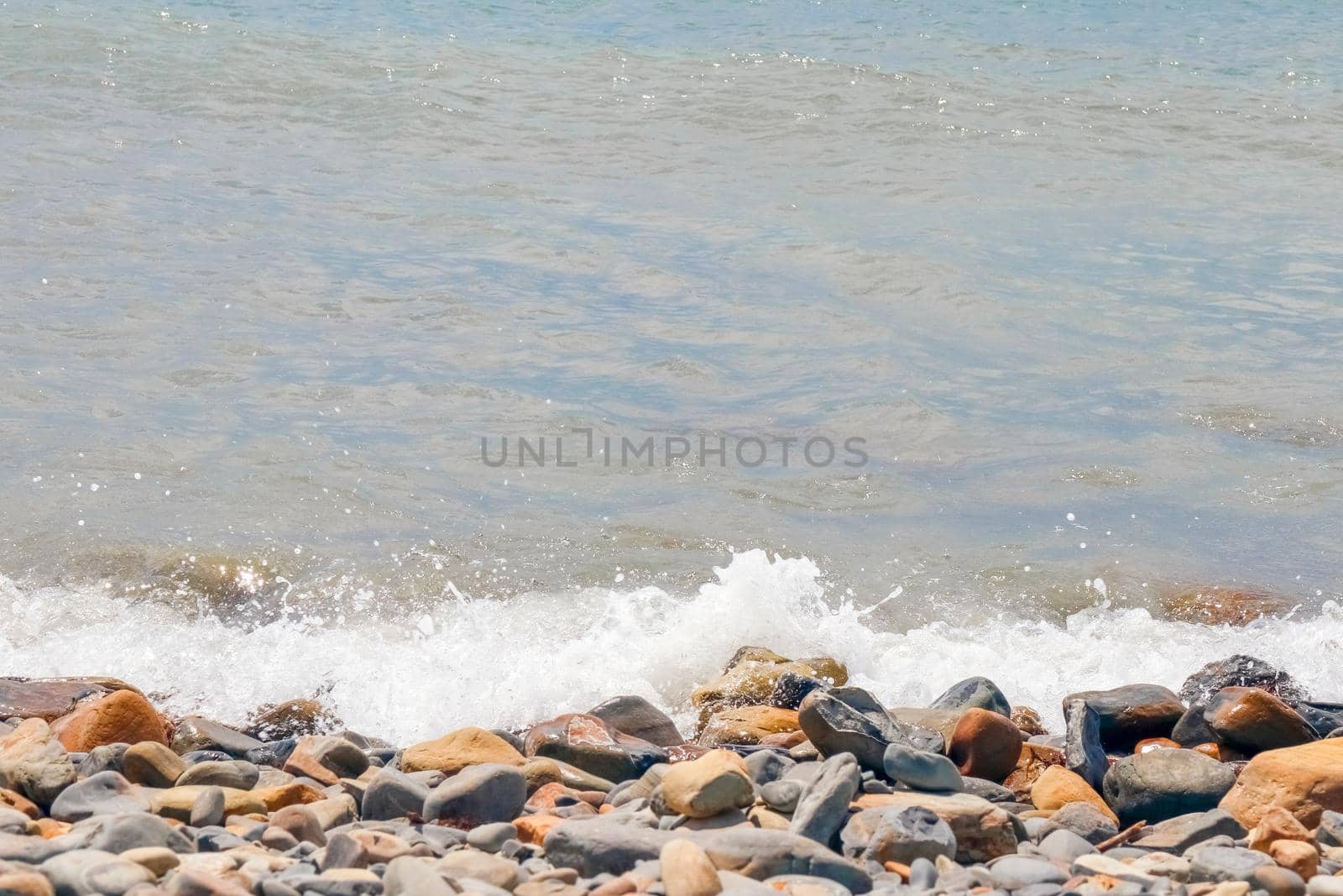 pebbles and stones on the beach. waves and splashes on the shore. High quality photo