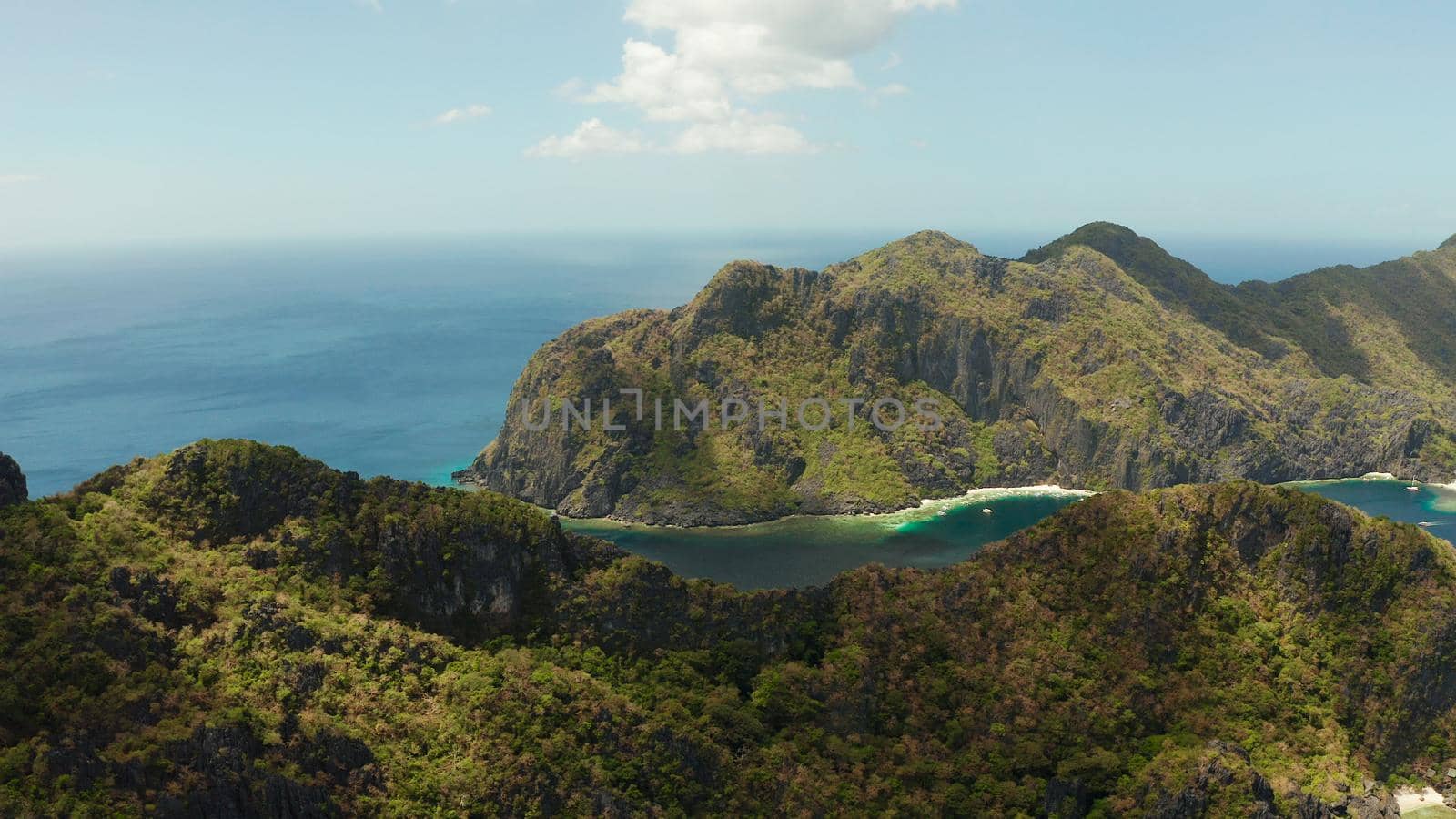 Bay and the tropical islands. Seascape with tropical rocky islands, ocean blue wate, aerial view. islands and mountains covered with tropical forest. El nido, Philippines, Palawan. Tropical Mountain Range