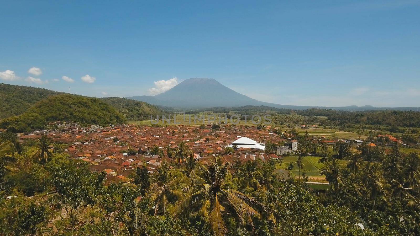 Aerial view Town near volcano Agung, rice terrace, farmlands, village, fields with crops, agricultural land of farmers. Bali, Indonesia