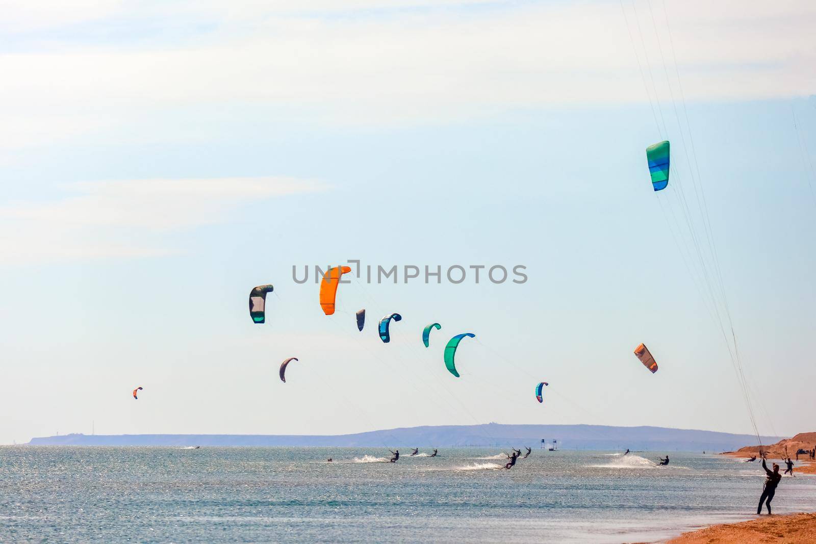 a kitesurfer surfing on the smooth azure water. recreational sport. A Man Rides A Kiteboarding In The Sea Water. extreme sport. Jump by roman112007