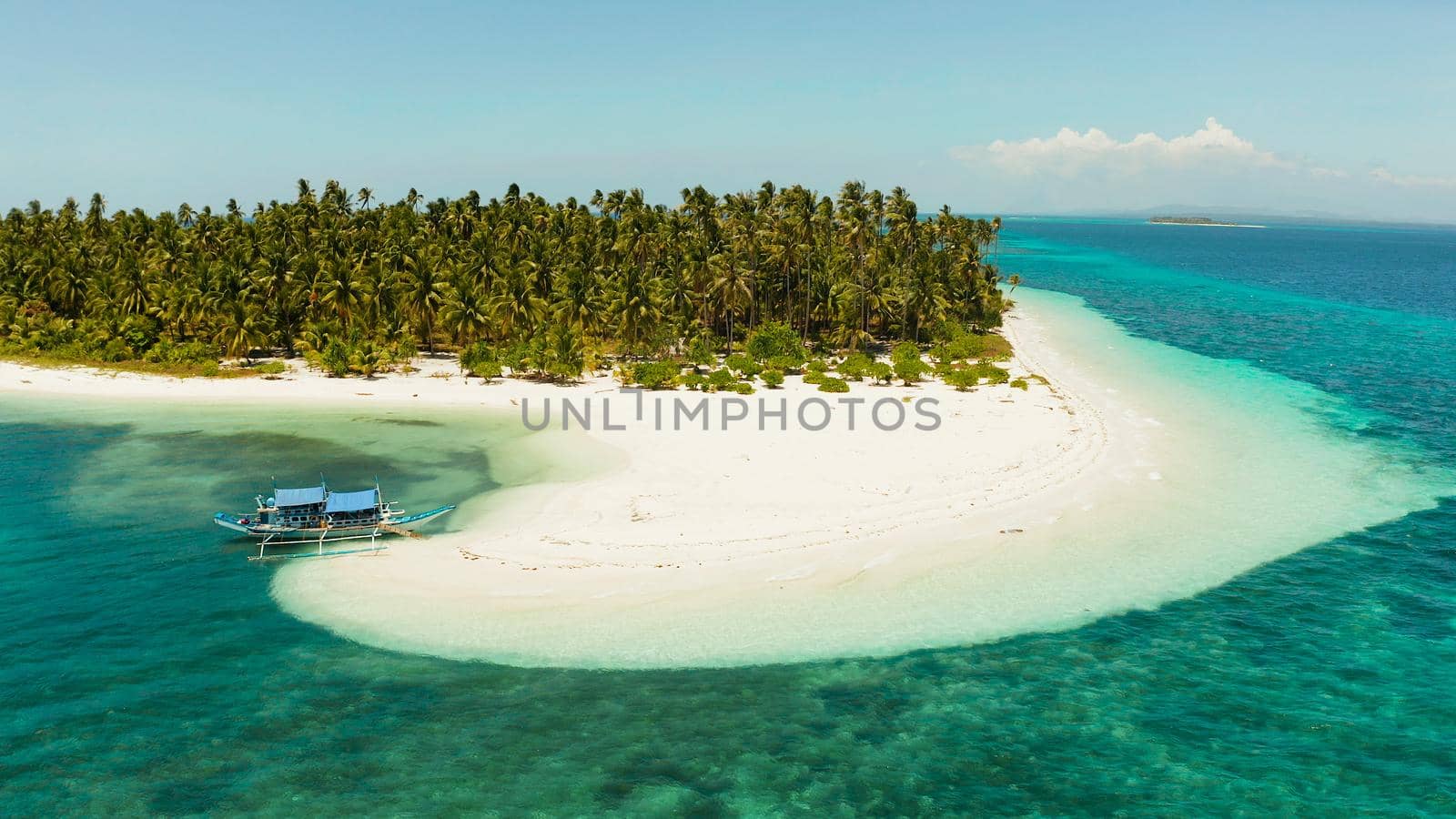 Tropical island with sandy beach by atoll with coral reef and blue sea, aerial view. Patongong Island with sandy beach. Summer and travel vacation concept.