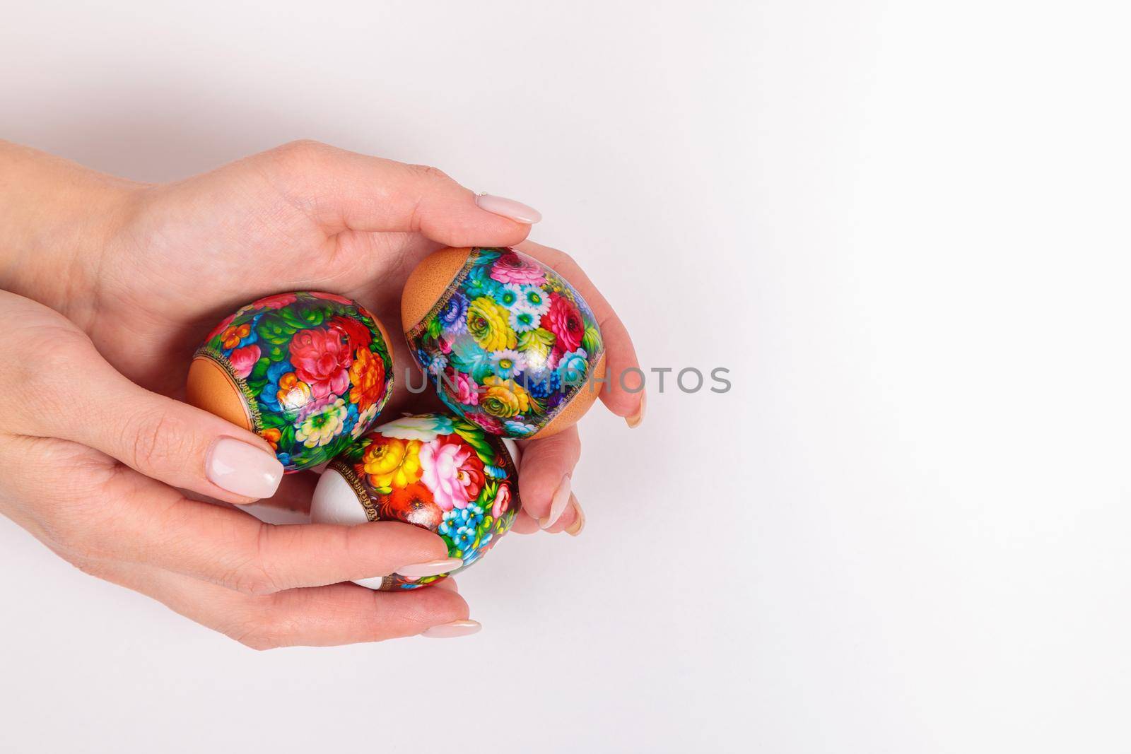 Easter. Khokhloma eggs in the hands of a girl, on a light background. Place for text. Egg Stickers