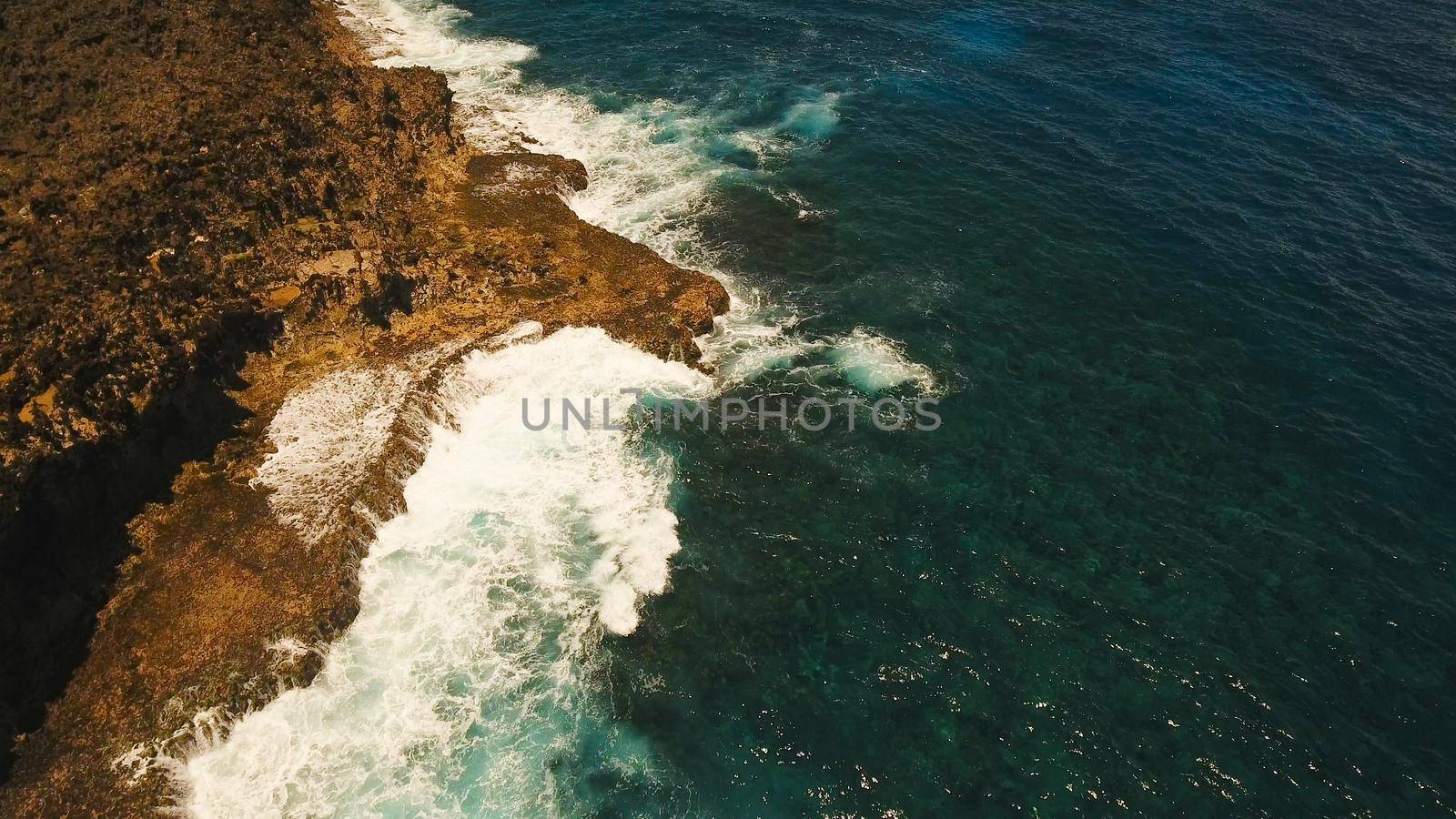Rocky coast line of Island Siargao. Aerial view sea rocky coast, waves breaking to the rocky shore. Sea landscape, rocks, waves breaking about the shore. Rocky coastline. Philippines. Travel concept.