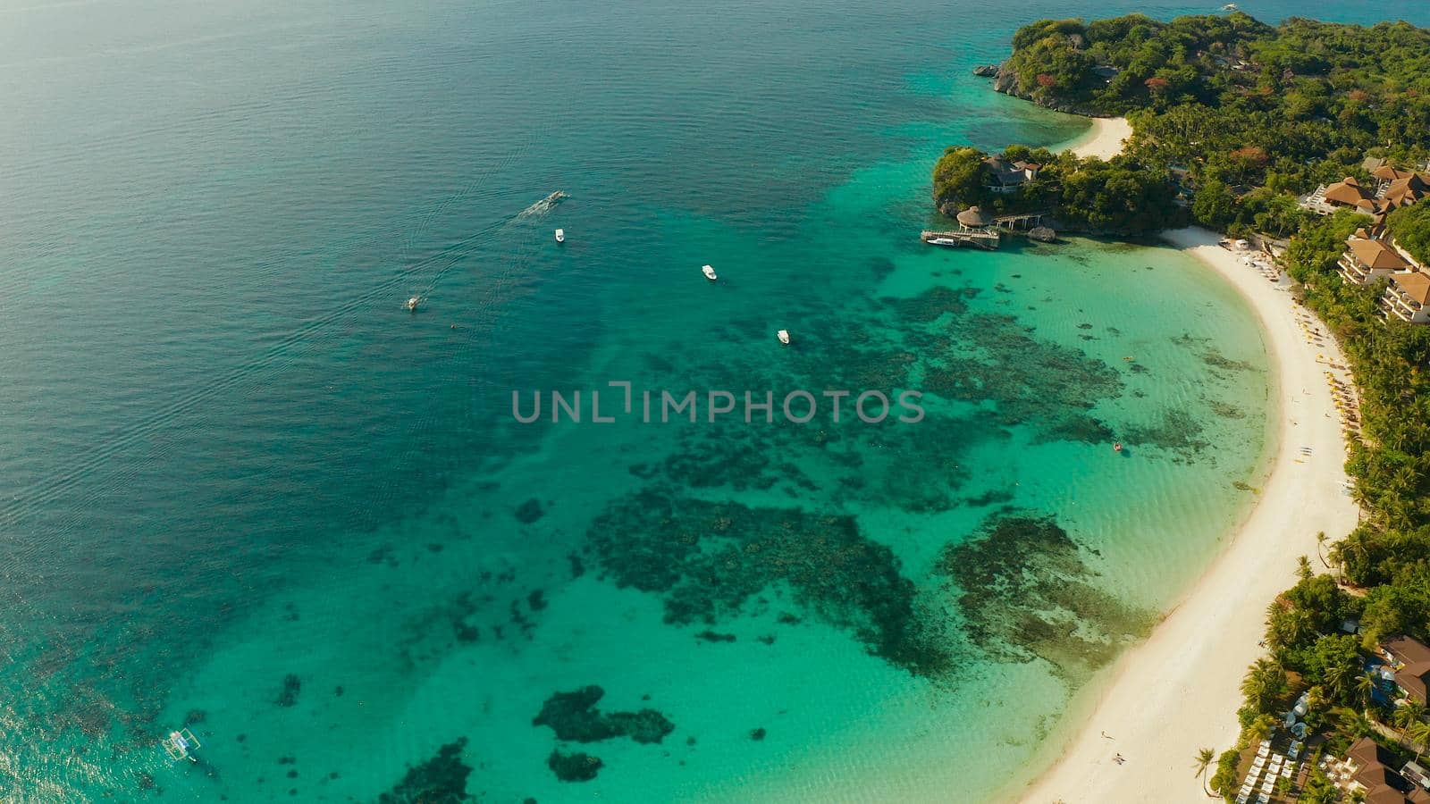 Tropical lagoon with turquoise water and white sand beach Boracay, Philippines. White beach with tourists and hotels. Tropical white beach with sailing boat.