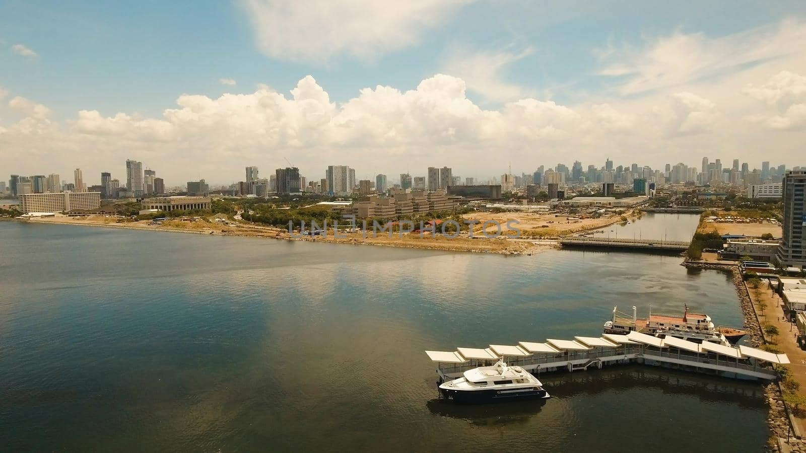 Aerial view of Manila city. Fly over city with skyscrapers and buildings. Aerial skyline of Manila. Modern city by sea, highway, cars, skyscrapers, shopping malls. Makati district. Travel concept.
