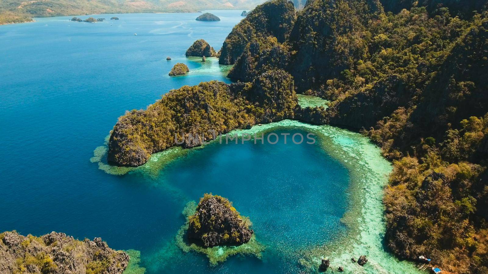 Tropical lagoon with azure water, beach by the Kayangan Lake, Philippines. Aerial view Coron island, with cove, bay at Kayangan lake. Lagoon with sailing boats. Aerial video. Philippines. Travel concept