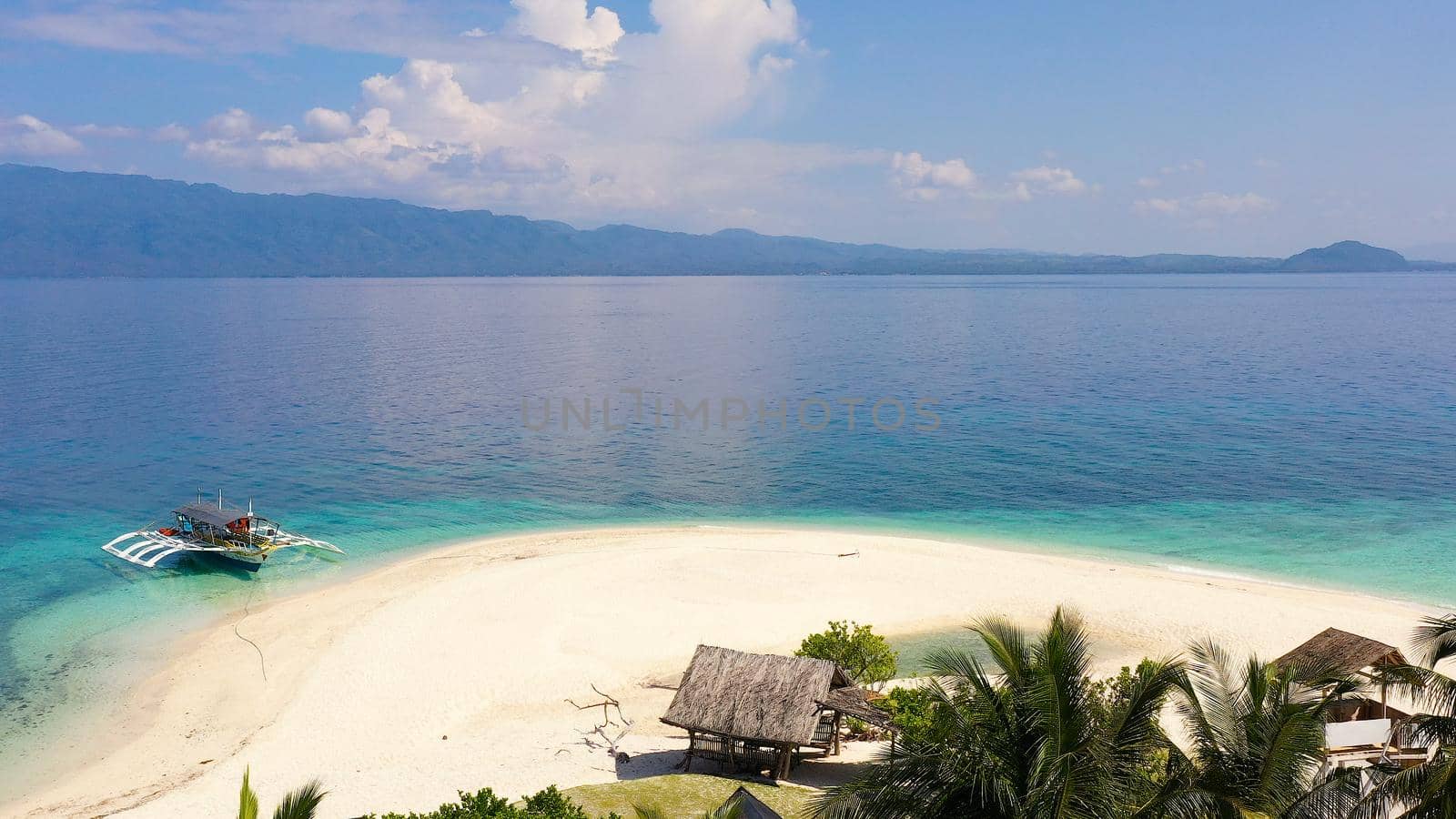 Perfect beach with blue water and white sand. Boat off the coast of a tropical island. Summer and travel vacation concept. Digyo Island, Philippines. Holiday and vacation concept.