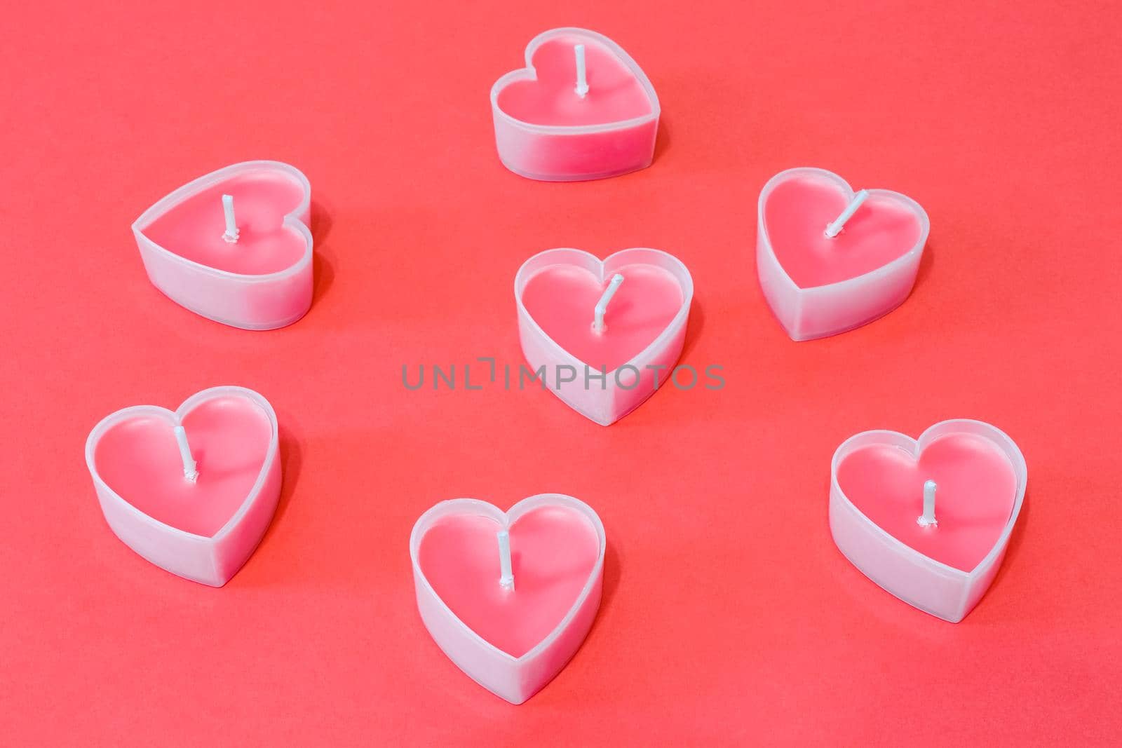 pink candles in the form of a heart on a red background for Valentine's day . High quality photo