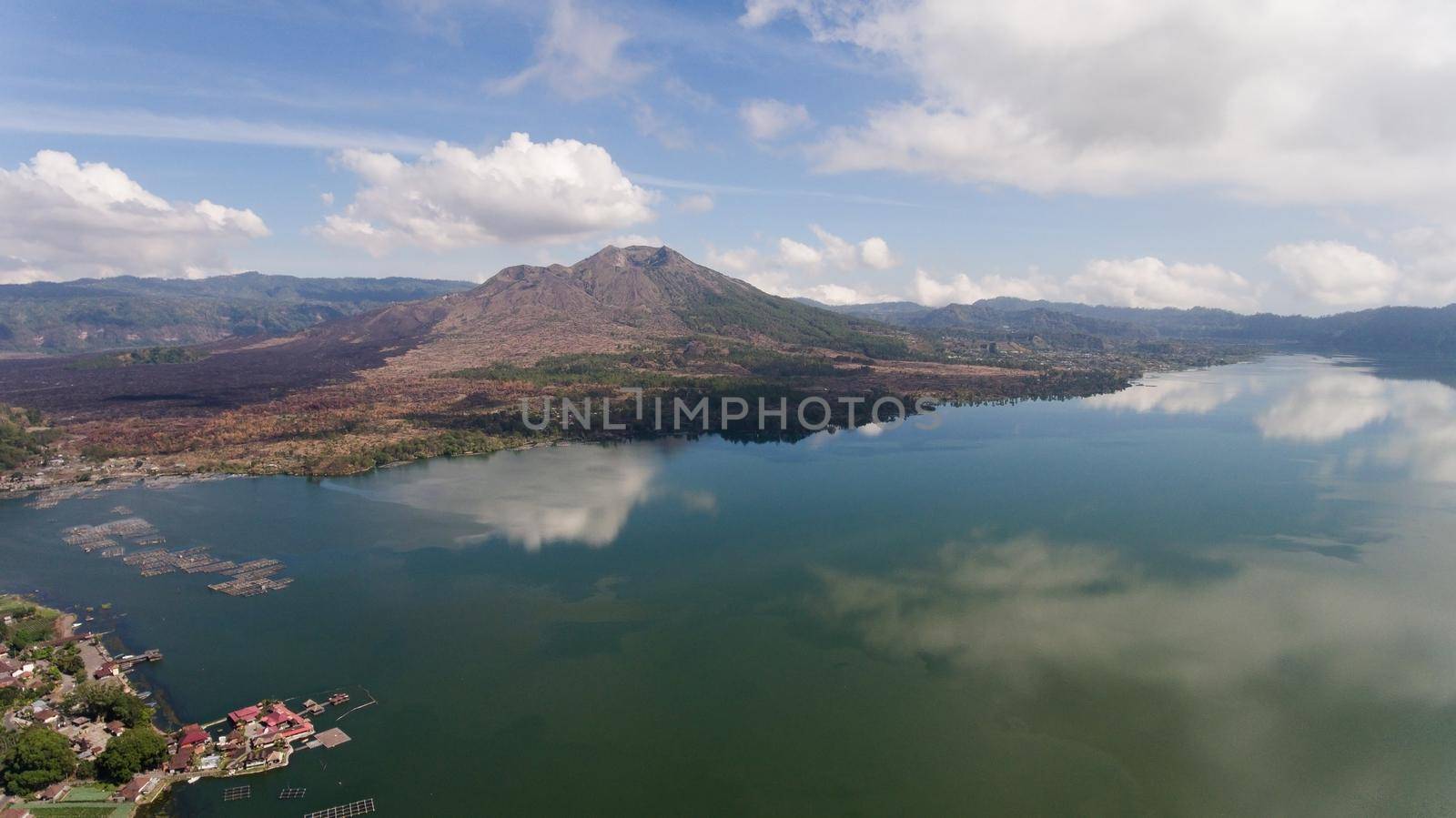 Aerial view Mountains, volcanoes, crater lake Batur, Bali, Indonesia. Mountain landscape with volcanoes, lake, sky and clouds. Travel concept