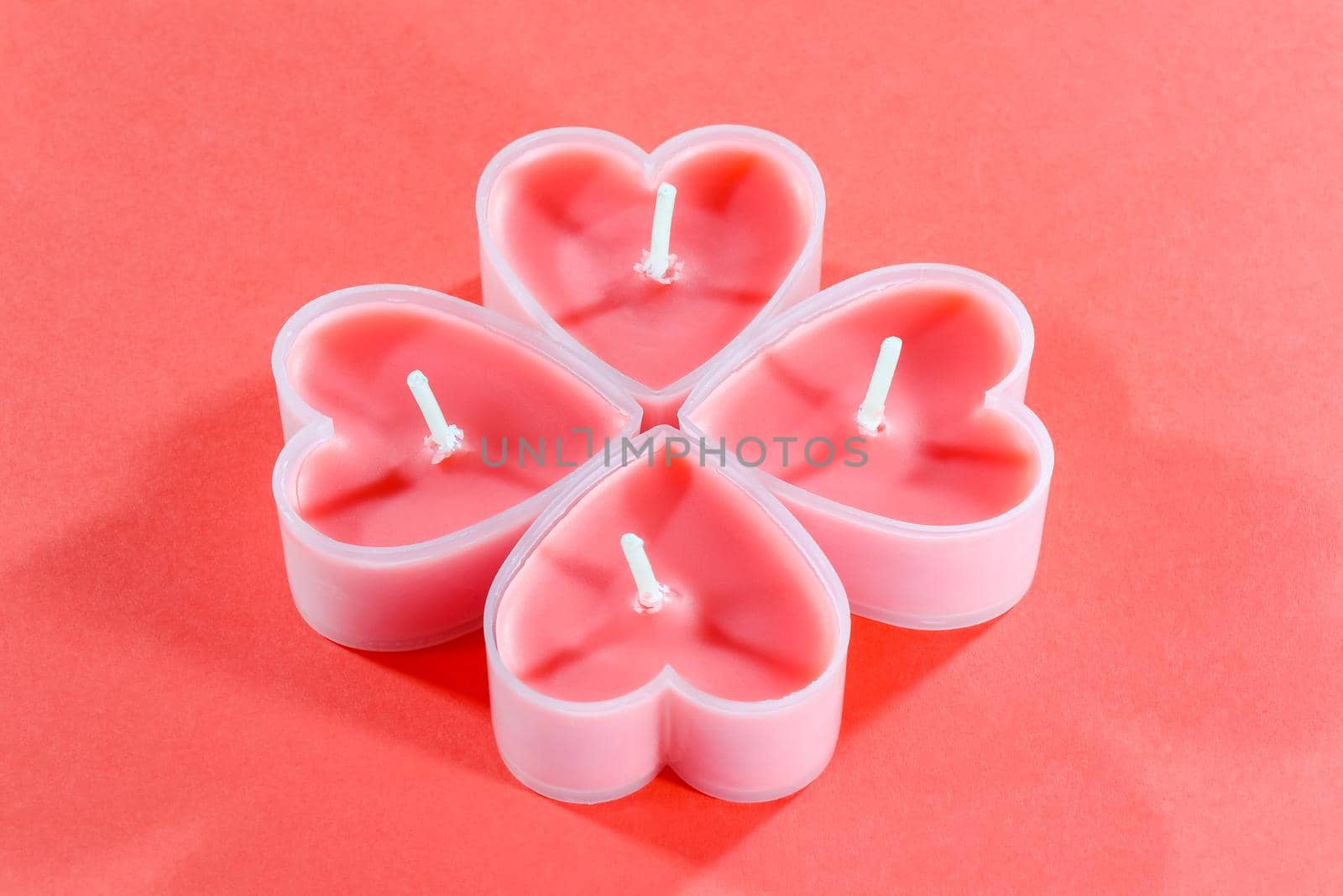 pink candles in the form of a heart on a red background for Valentine's day . High quality photo