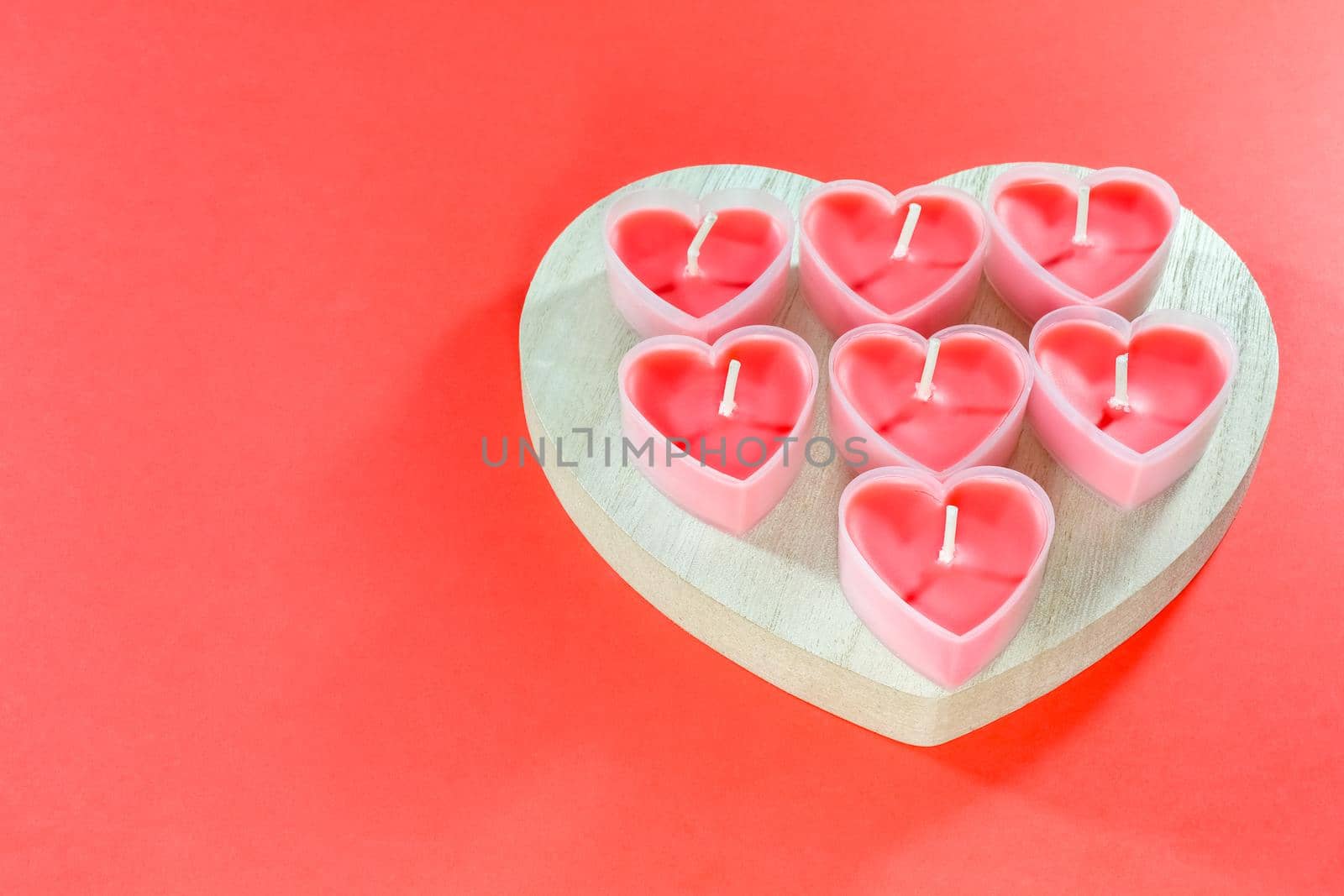 pink candles in the form of a heart on a red background for Valentine's day . High quality photo