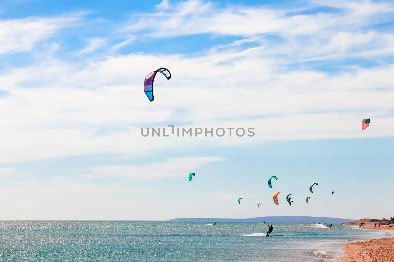 a kitesurfer surfing on the smooth azure water. recreational sport. A Man Rides A Kiteboarding In The Sea Water. extreme sport. Jump by roman112007