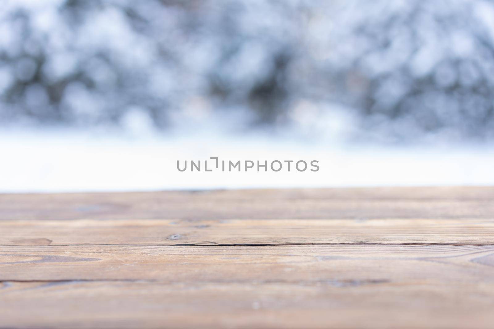 Beautiful winter scene. blurred background of snowy christmas nature background, Wood table top on shiny bokeh. For product display Christmas time mock up