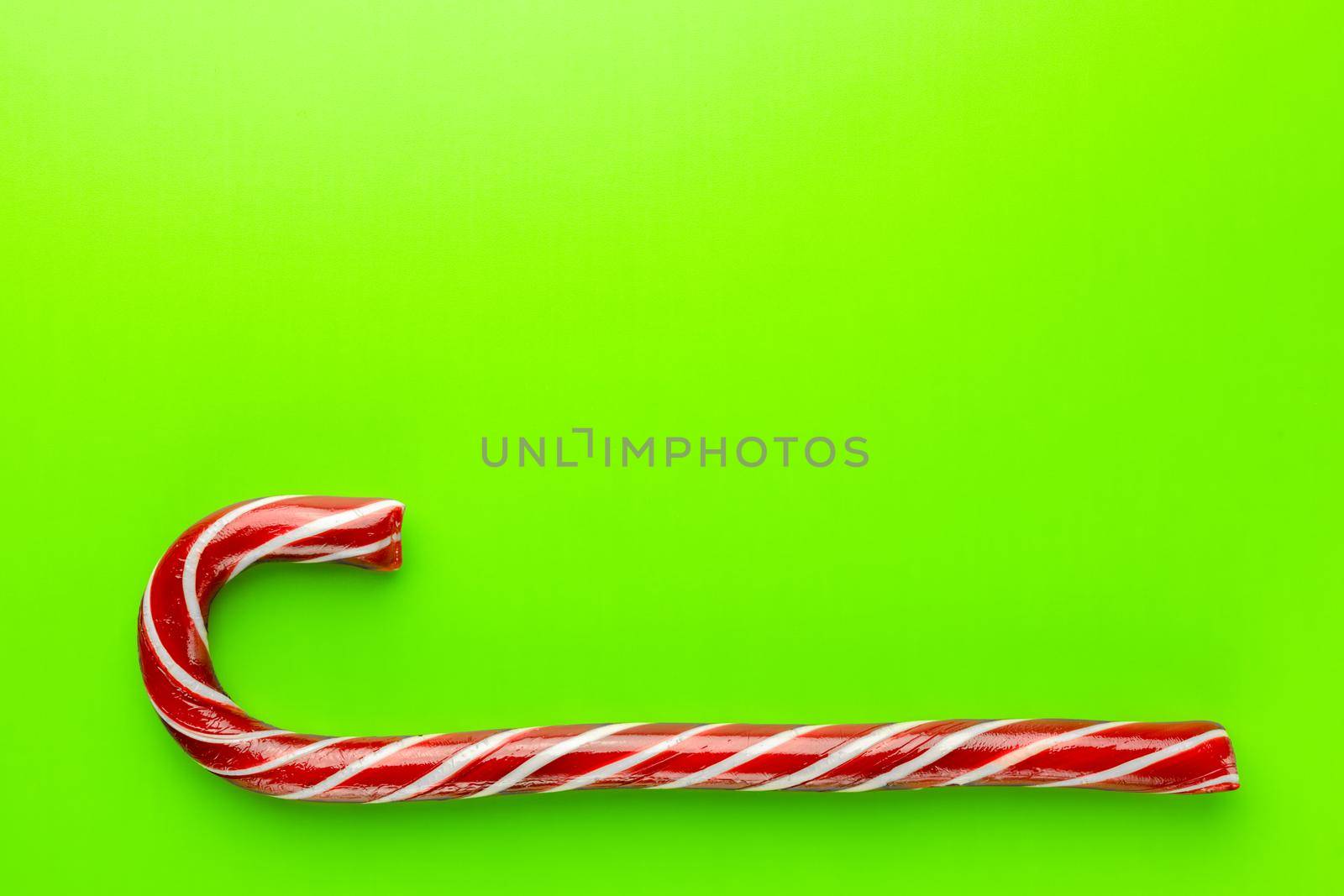 caramel Christmas cane on a green background. High quality photo