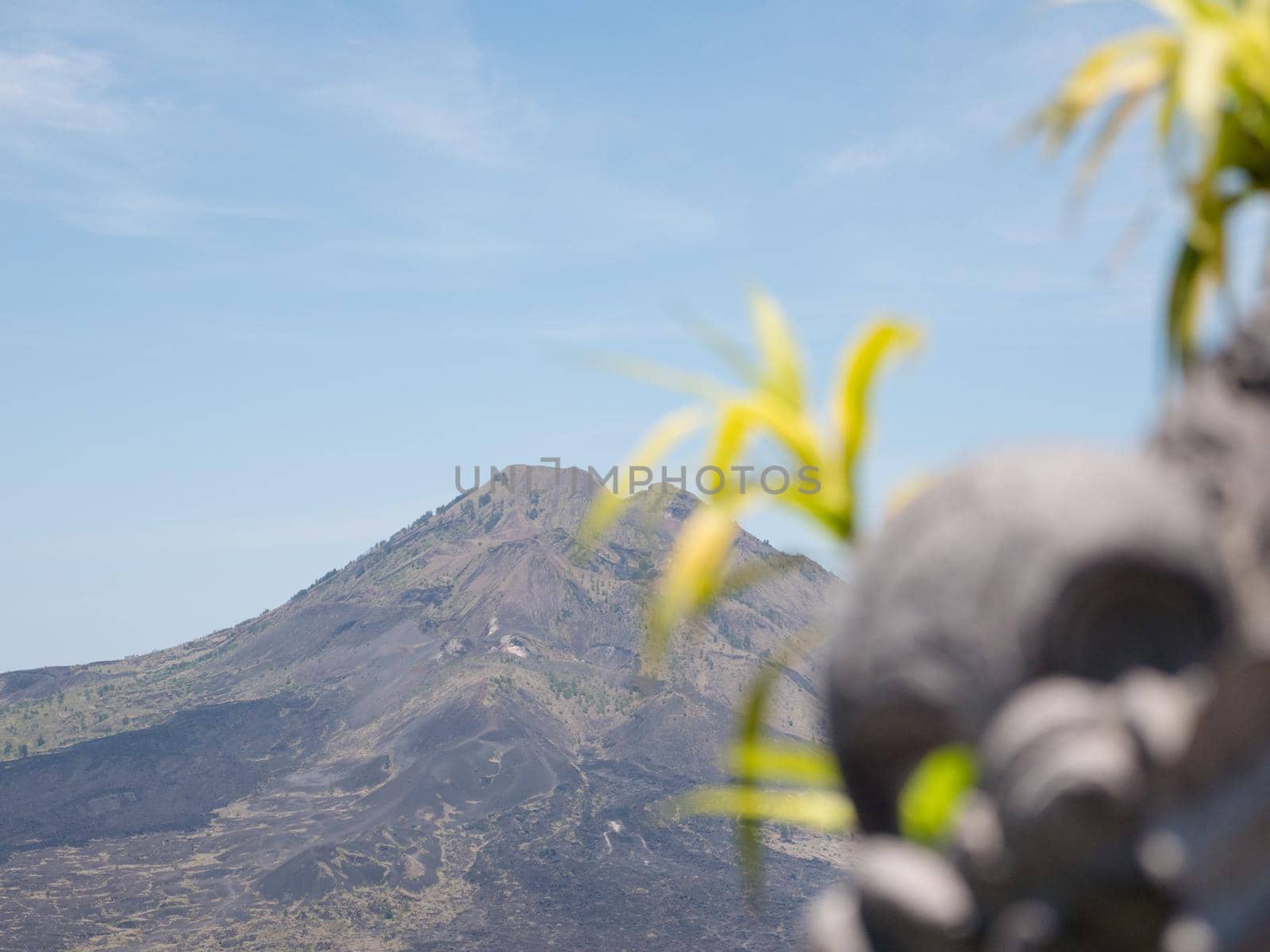 Volcano, mountain covered forest, sky with clouds, traces of lava on the ground. Mount Batur Volcano in Kintamani. Mountain landscape, Bali. Travel concept.