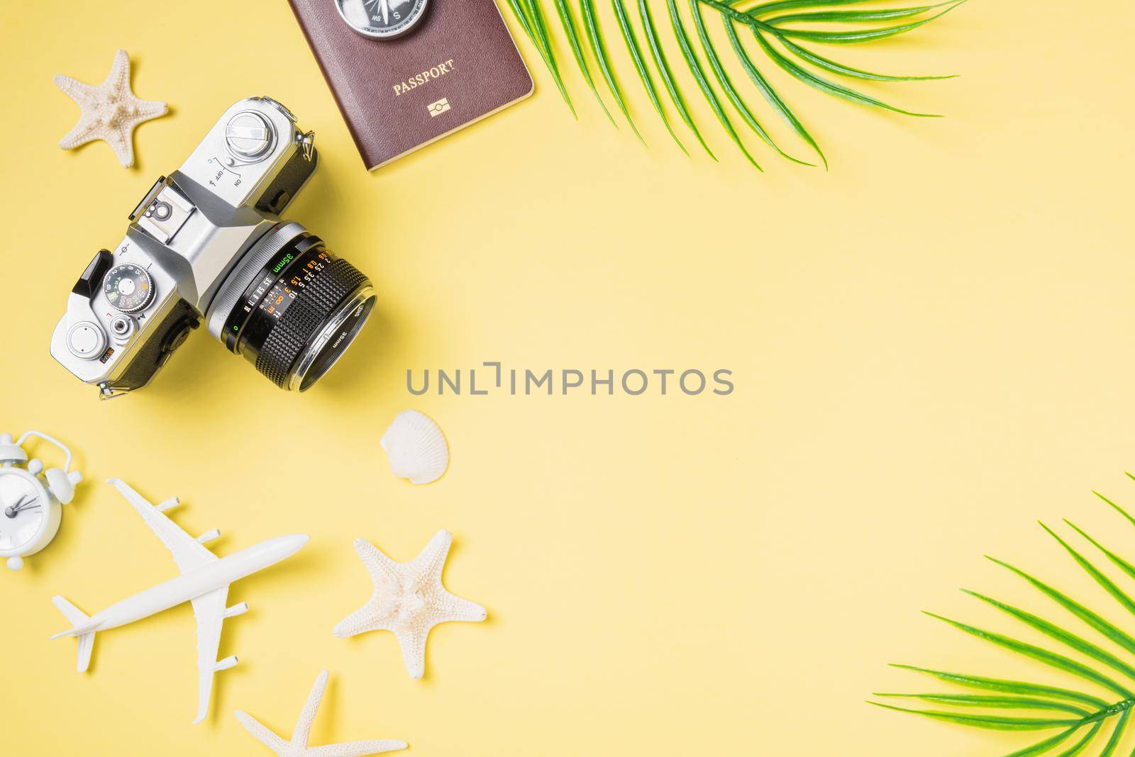 Flat lay top view mockup retro camera films, airplane, passport, starfish traveler tropical beach accessories on a yellow background with copy space, Vacation summer travel and business trip concept