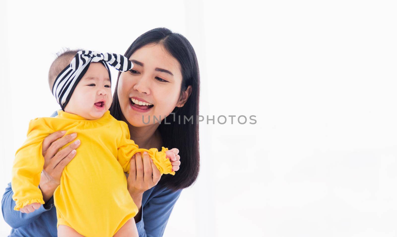mother playing and smiling together with his newborn little baby by Sorapop
