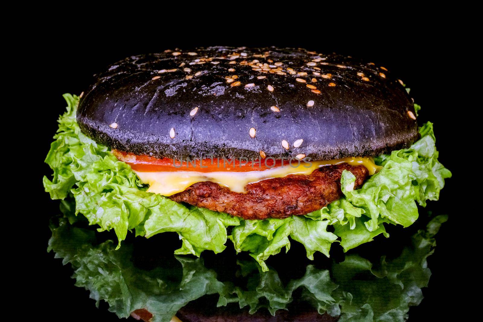 black hamburger close up on a black background macro isolate