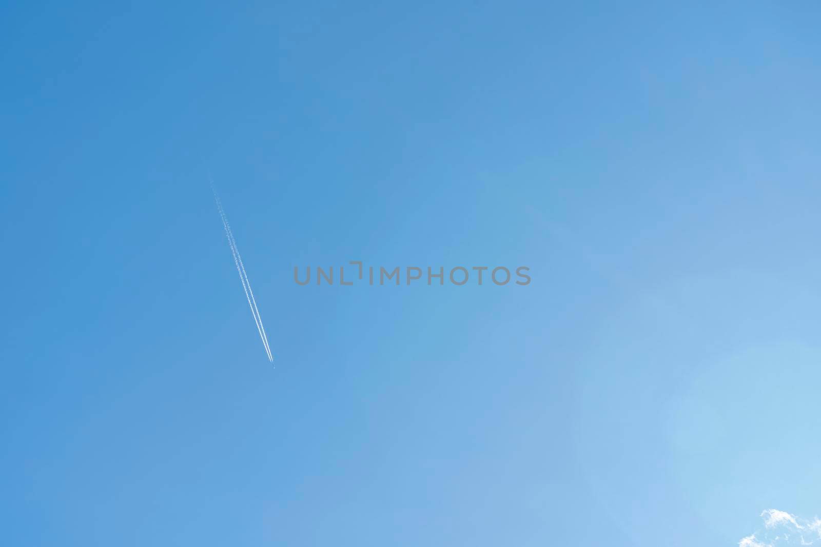 the plane and its footprint in the blue sky. High quality photo