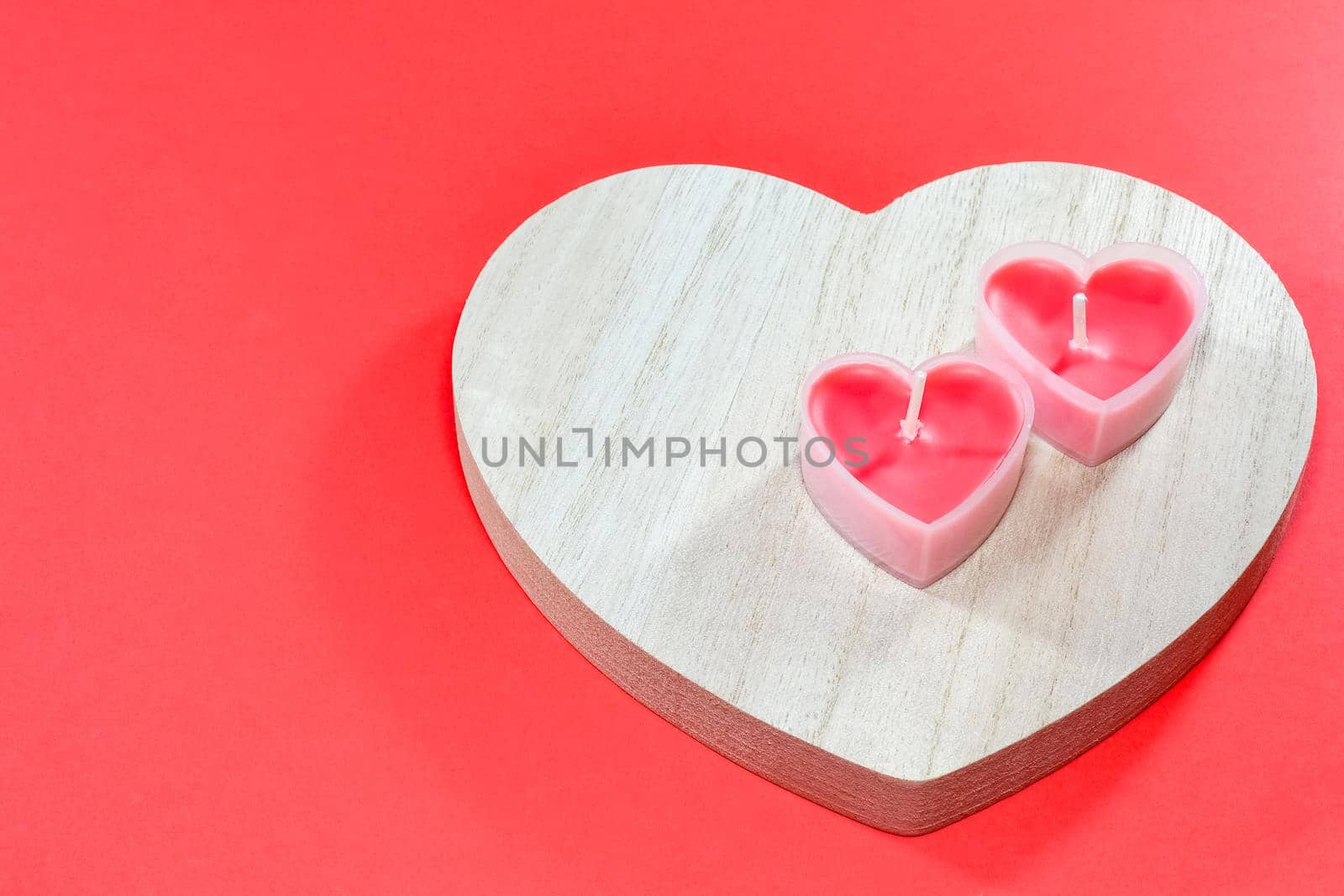 pink candles in the form of a heart on a red background for Valentine's day . High quality photo