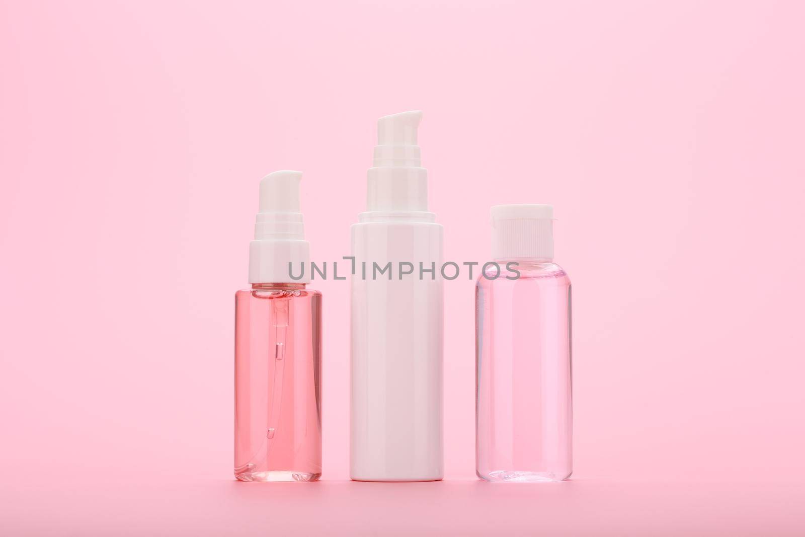 Cleaning foam, face cream and skin lotion against pink background. Concept of daily skin care or anti aging treatment