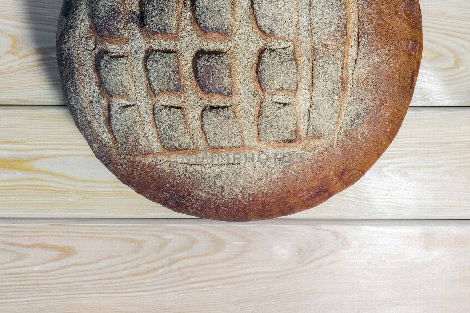 a loaf of bread on a wooden background by roman112007