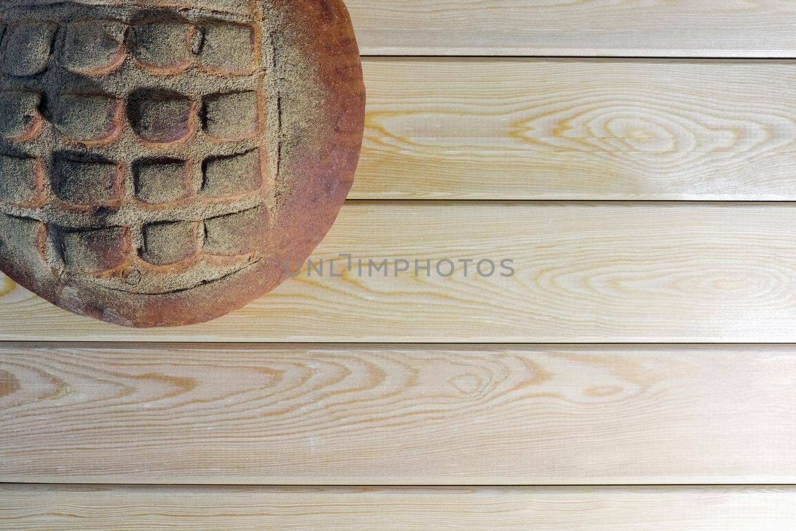 a loaf of bread on a wooden background by roman112007