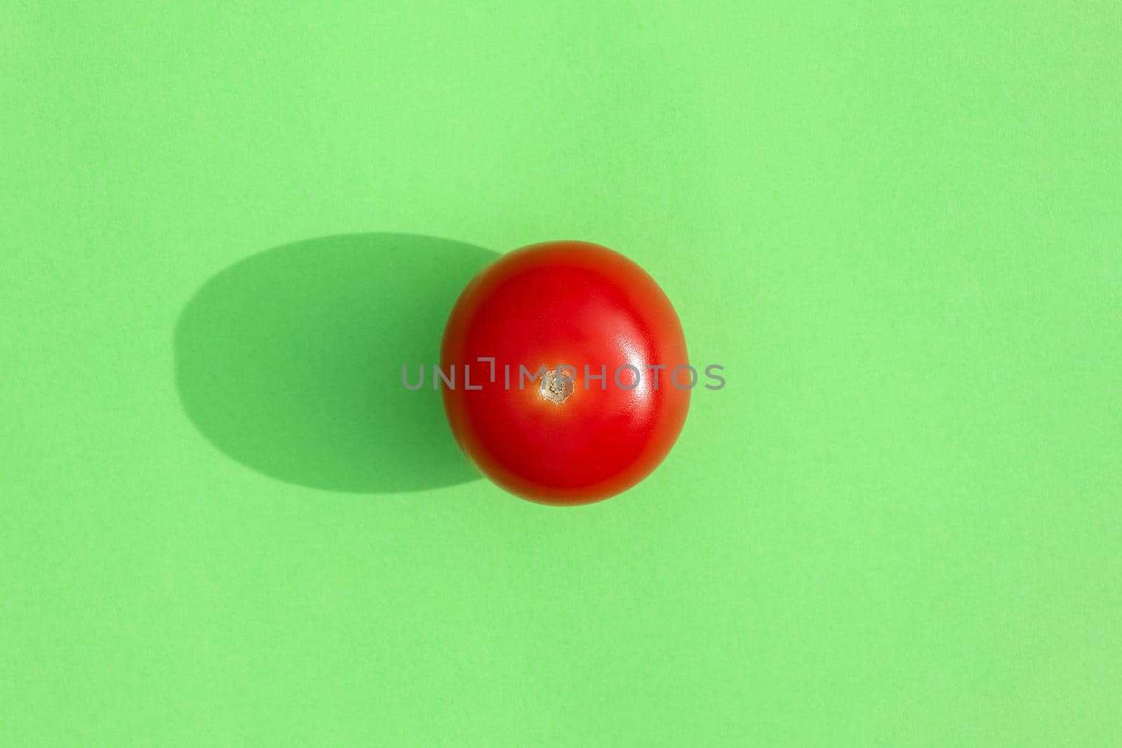 tomato with a hard shadow on a colored background pattern. High quality photo