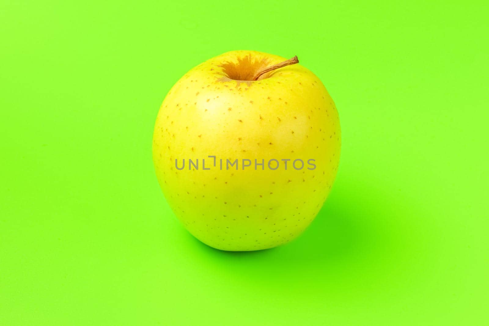 yellow Apple on a green background close-up.isolate. High quality photo