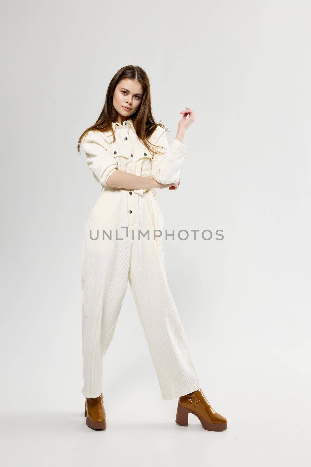 pretty woman in white jumpsuit fashion clothes brown shoes. High quality photo