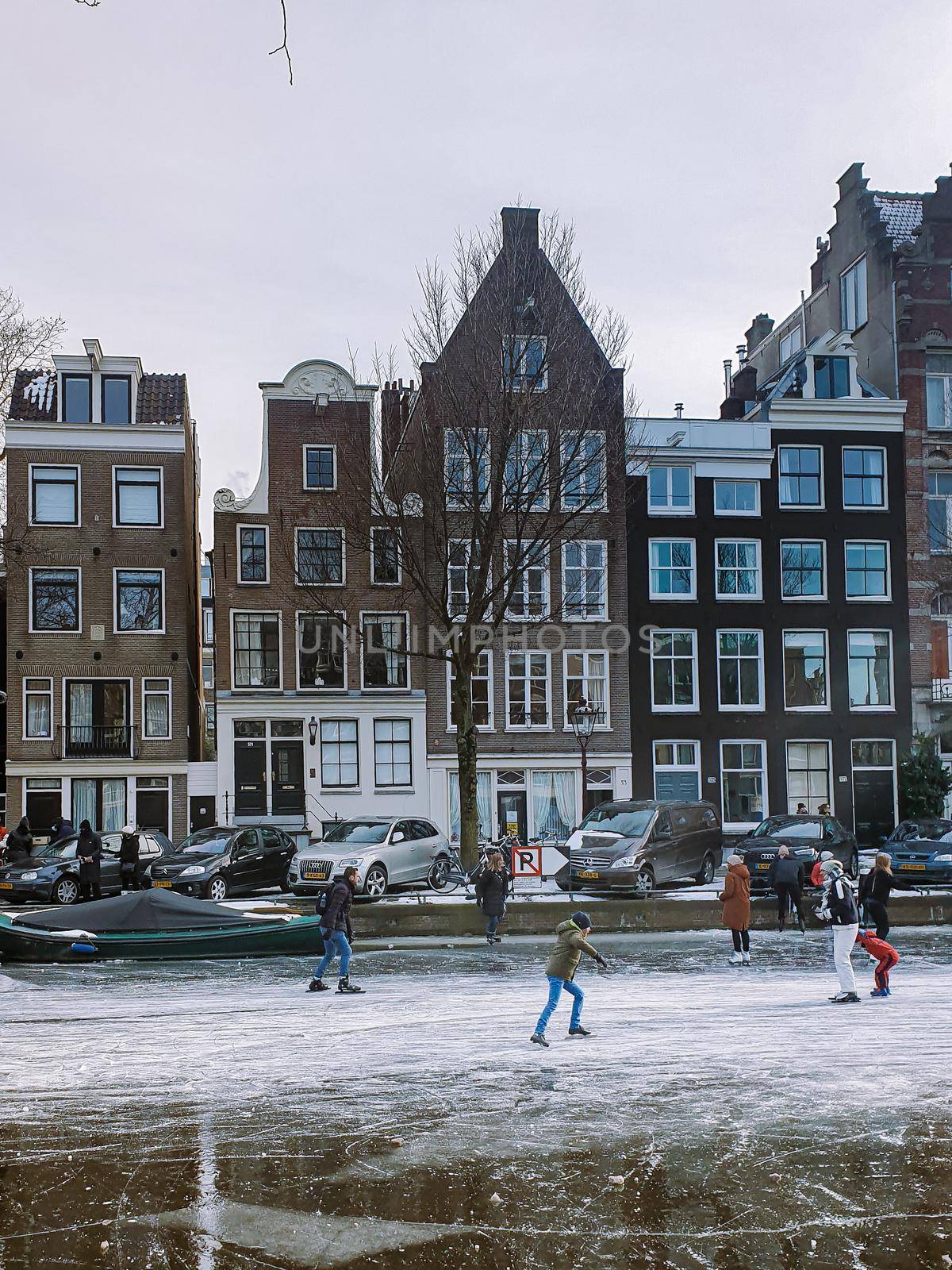 Amsterdam Netherlands, frozen canals and people ice skating in Amsterdam Netherlands february 2021
