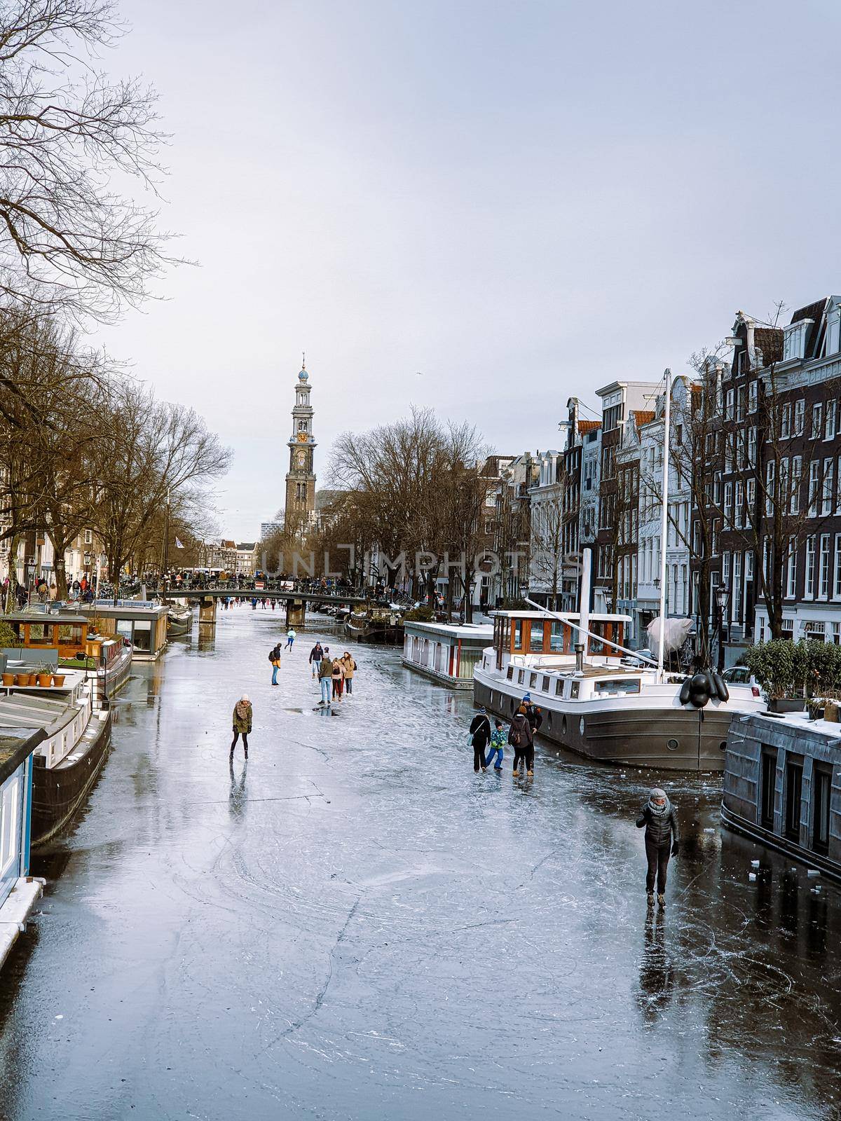 Amsterdam Netherlands, frozen canals and people ice skating in Amsterdam Netherlands february 2021