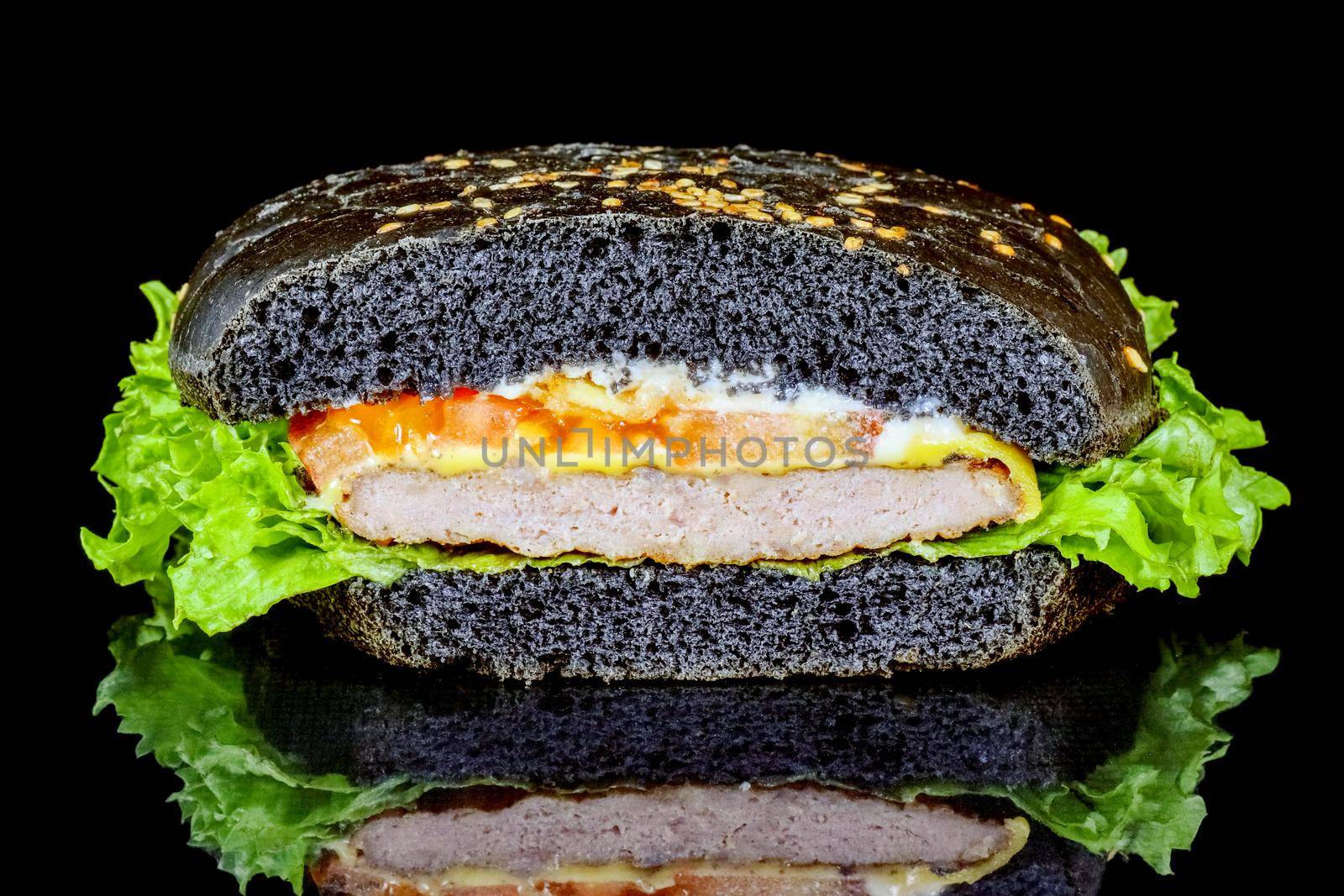 black hamburger close up on a black background macro isolate