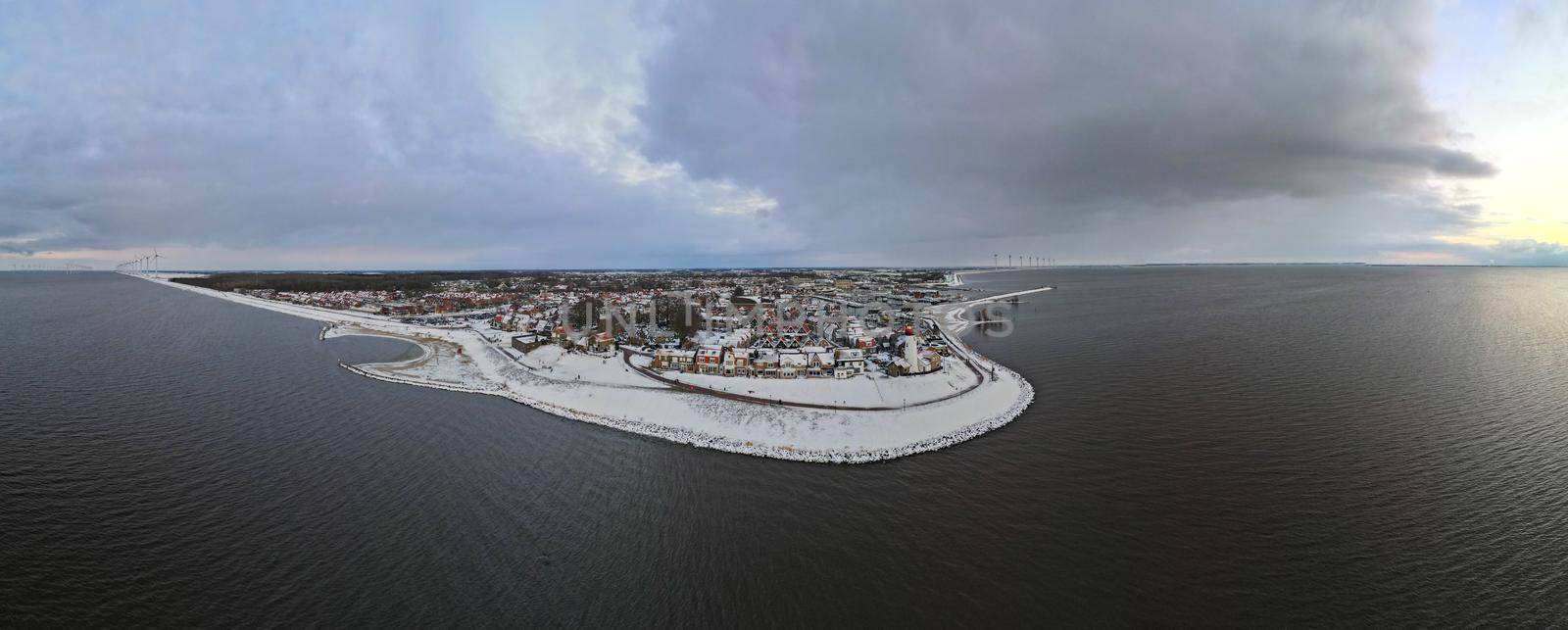 snow covered beach during wnter by Urk lighthouse in the Netherlands. cold winter weather in the Netherlands