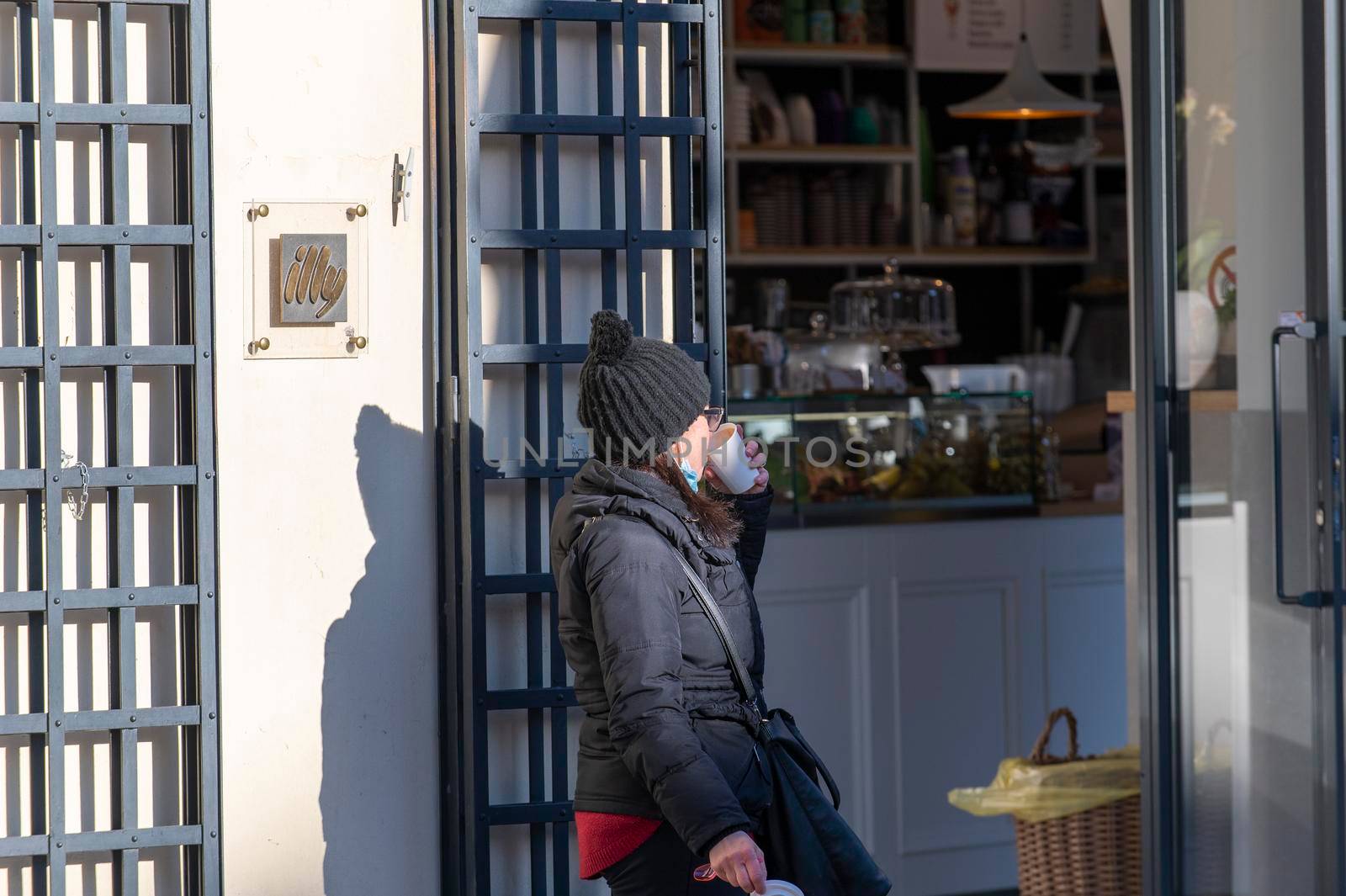 terni,italy february 15 2021:woman having breakfast outside the cafe due to corona virus