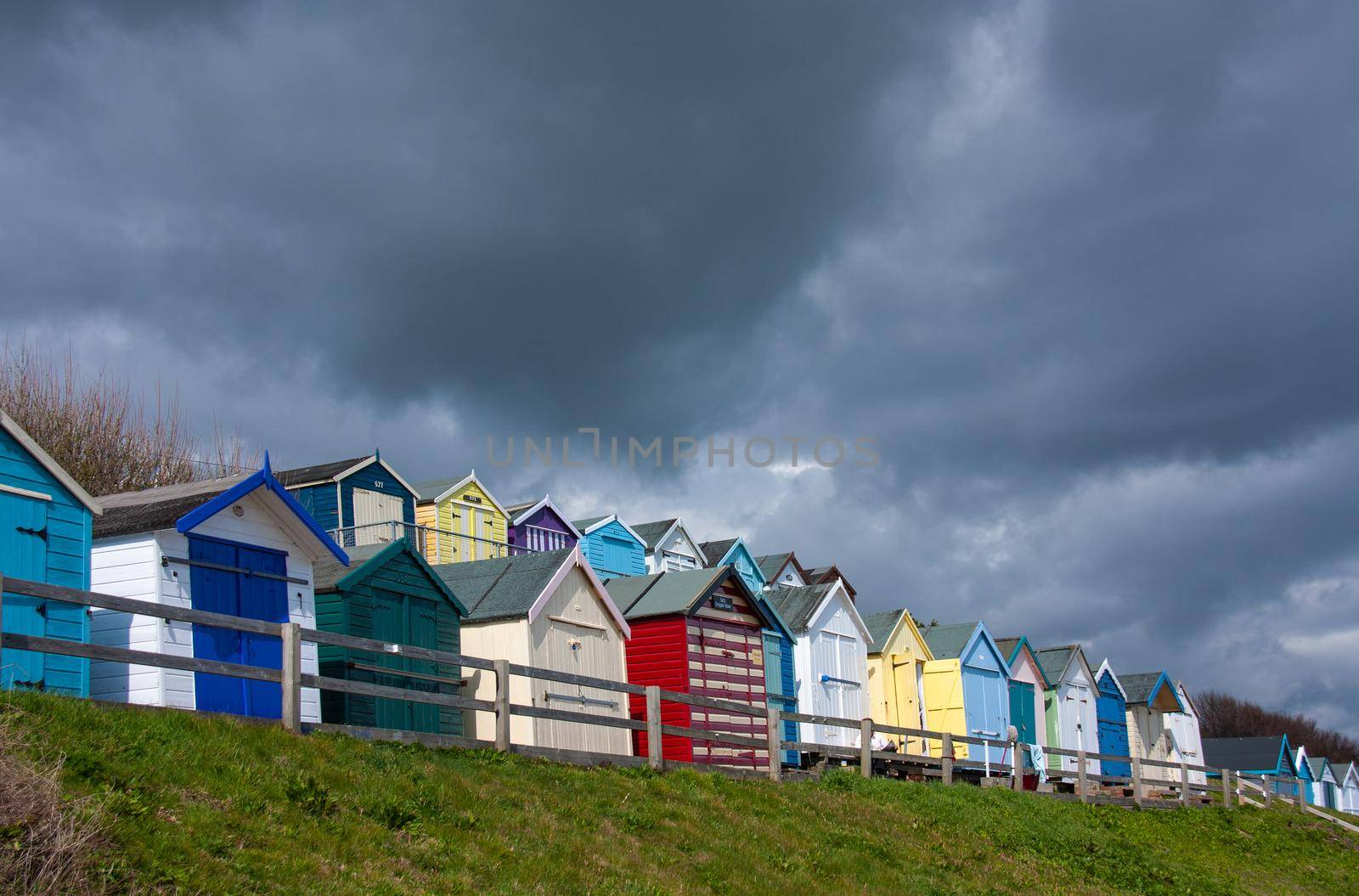 row of beach huts with a deep blue sky, colourful beach huts by NelliPolk