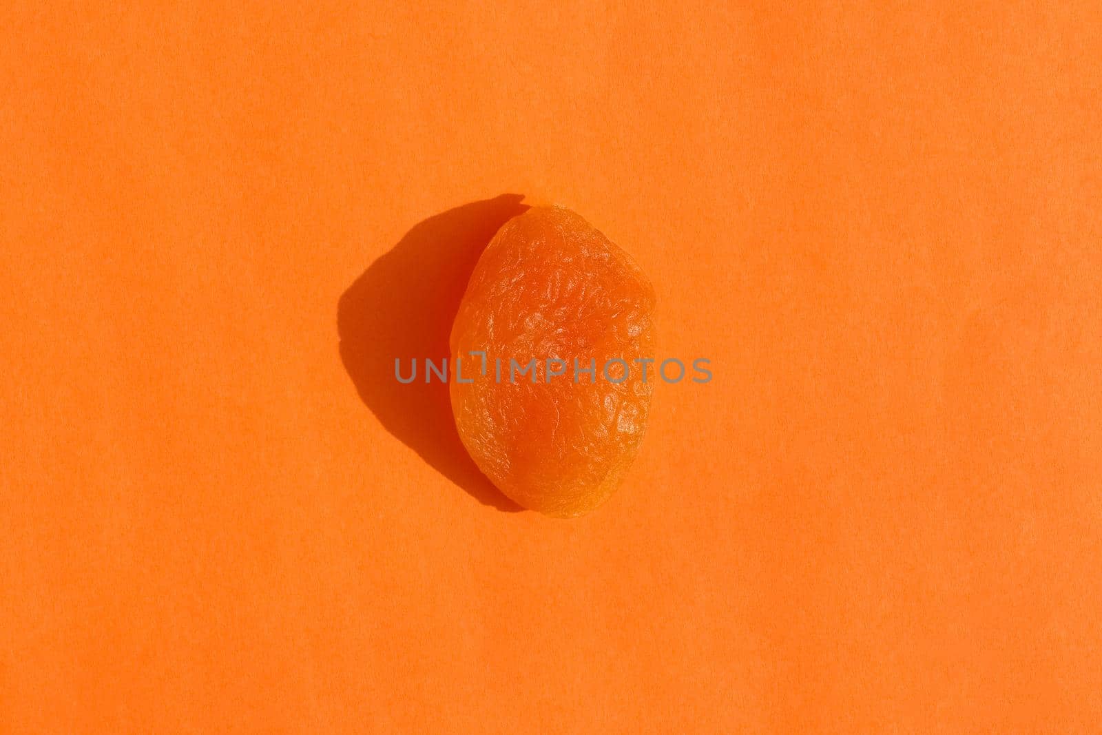 dried apricots with a hard shadow on a colored background pattern by roman112007