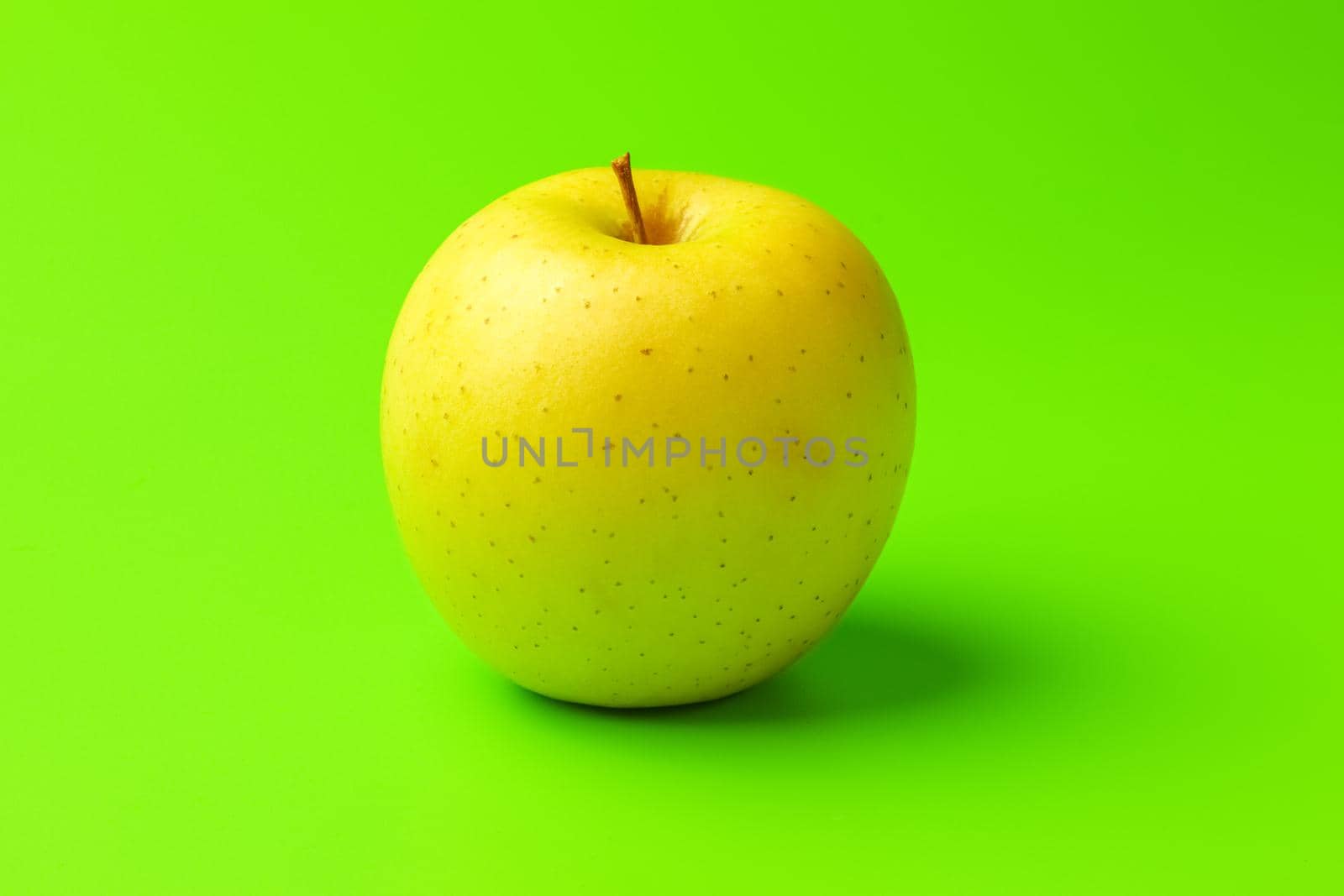 yellow Apple on a green background close-up.isolate by roman112007