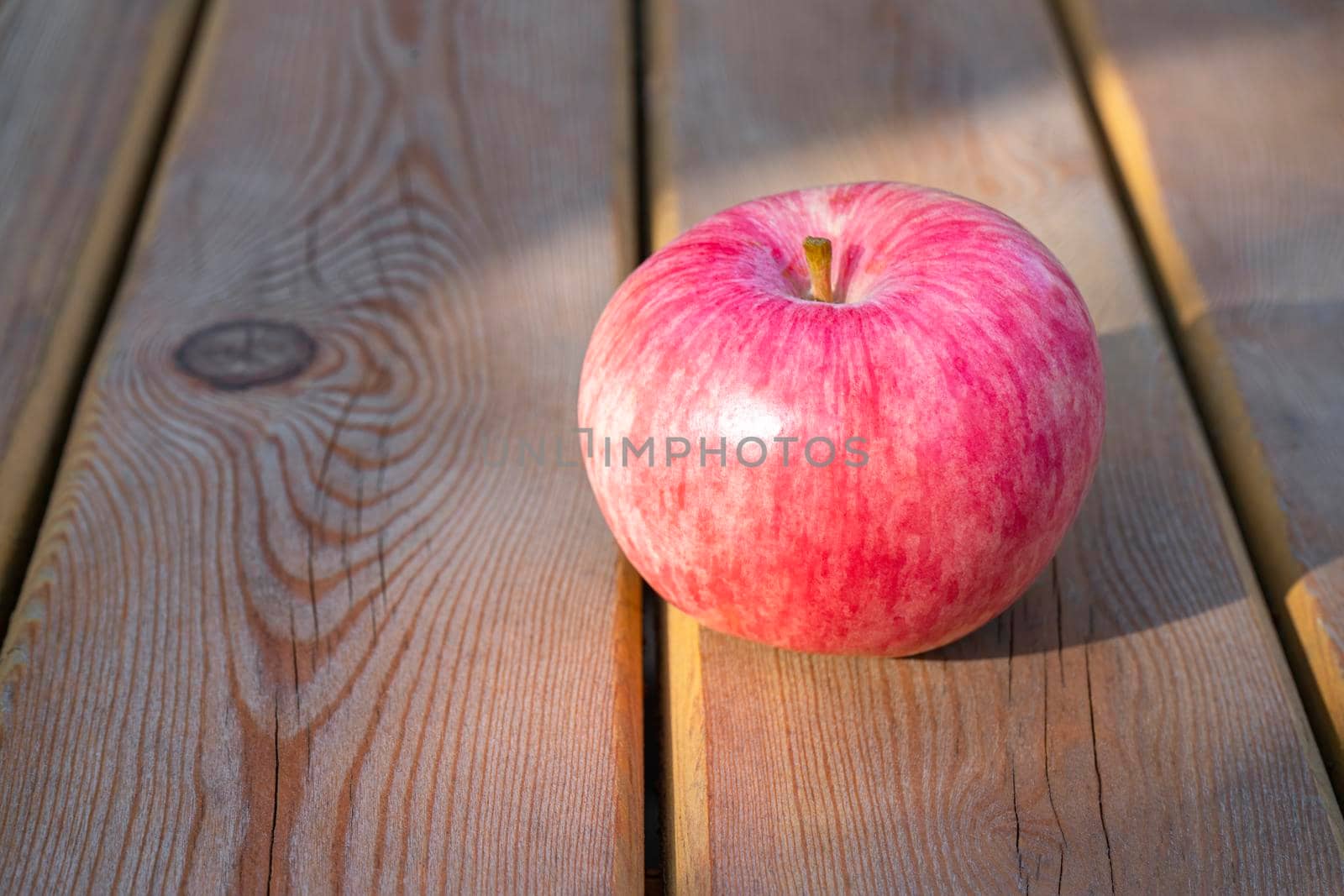 red Apple on a wooden table close-up by roman112007